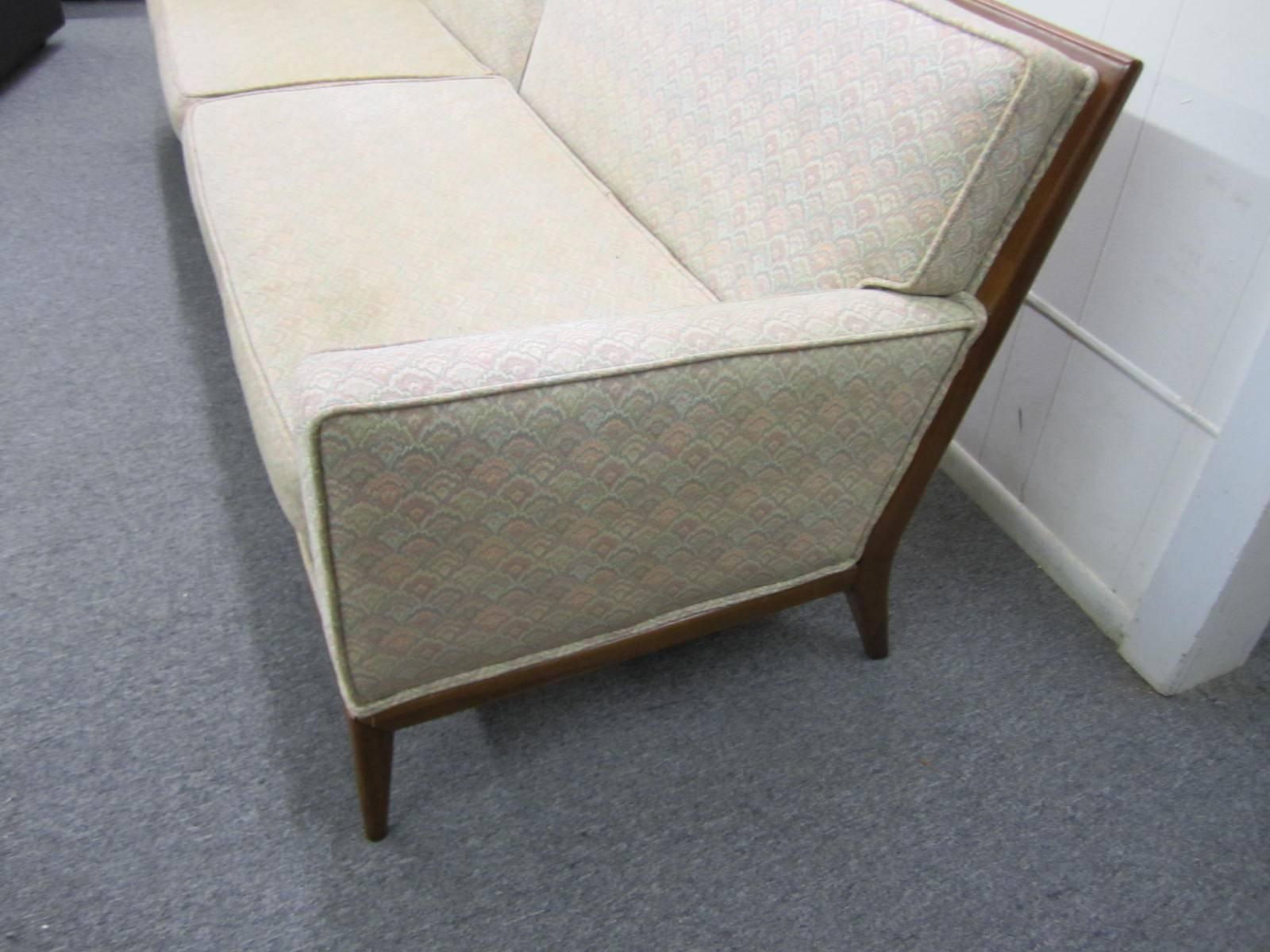 Gorgeous pair of Robsjohn-Gibbings style solid walnut framed sofas. Handsome solid walnut encases the entire back ending in graceful tapered legs. Fabulous looking from the front or back-place these sofas in the middle of the room for full viewing