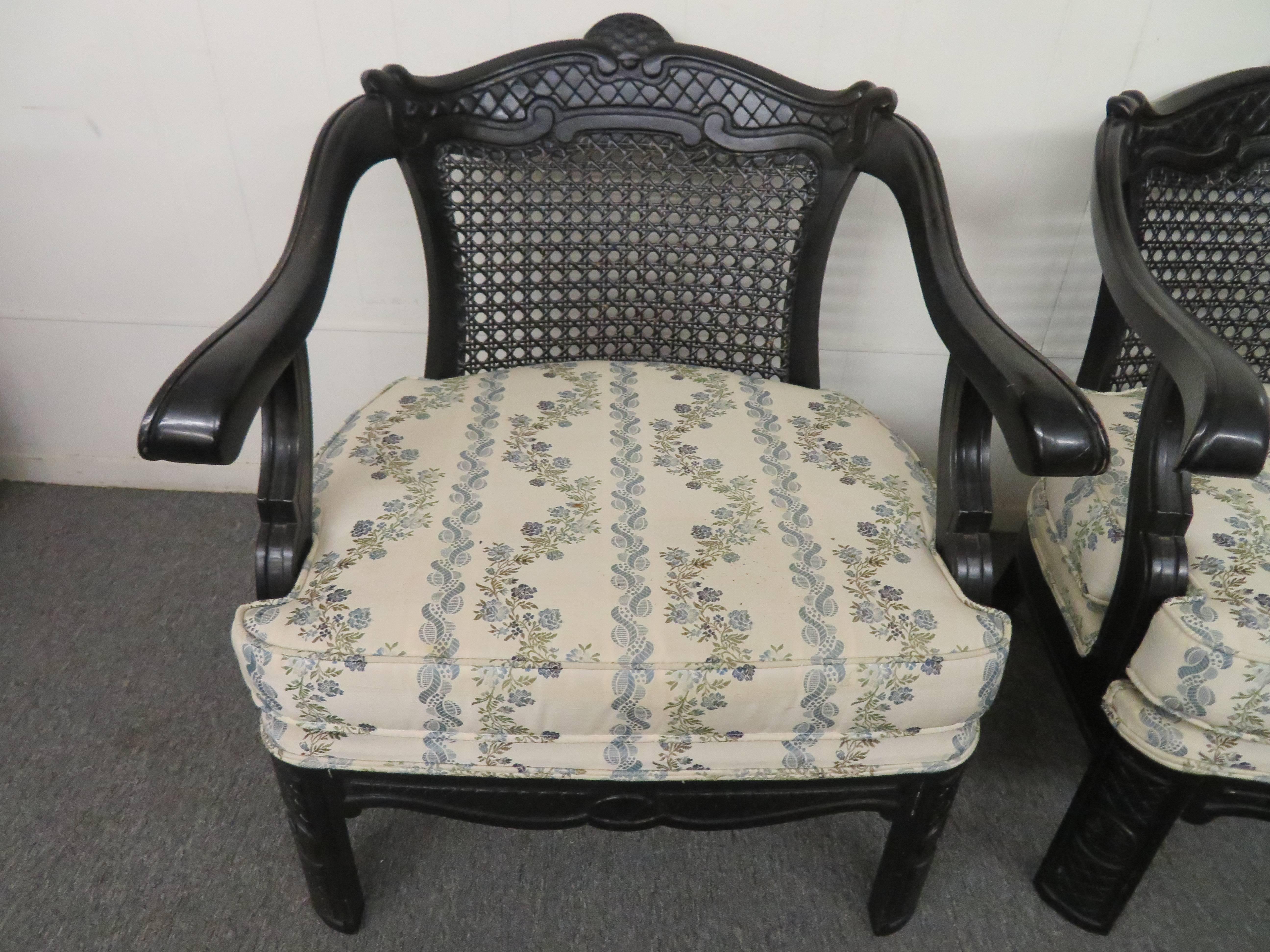 Lovely large-scale pair of chinoiserie style arm chairs with caned backs. We love the over-size wide seats and black lacquered finish. Great as is but you may like to give them a fresh new look with a colored lacquer finish and new upholstery.