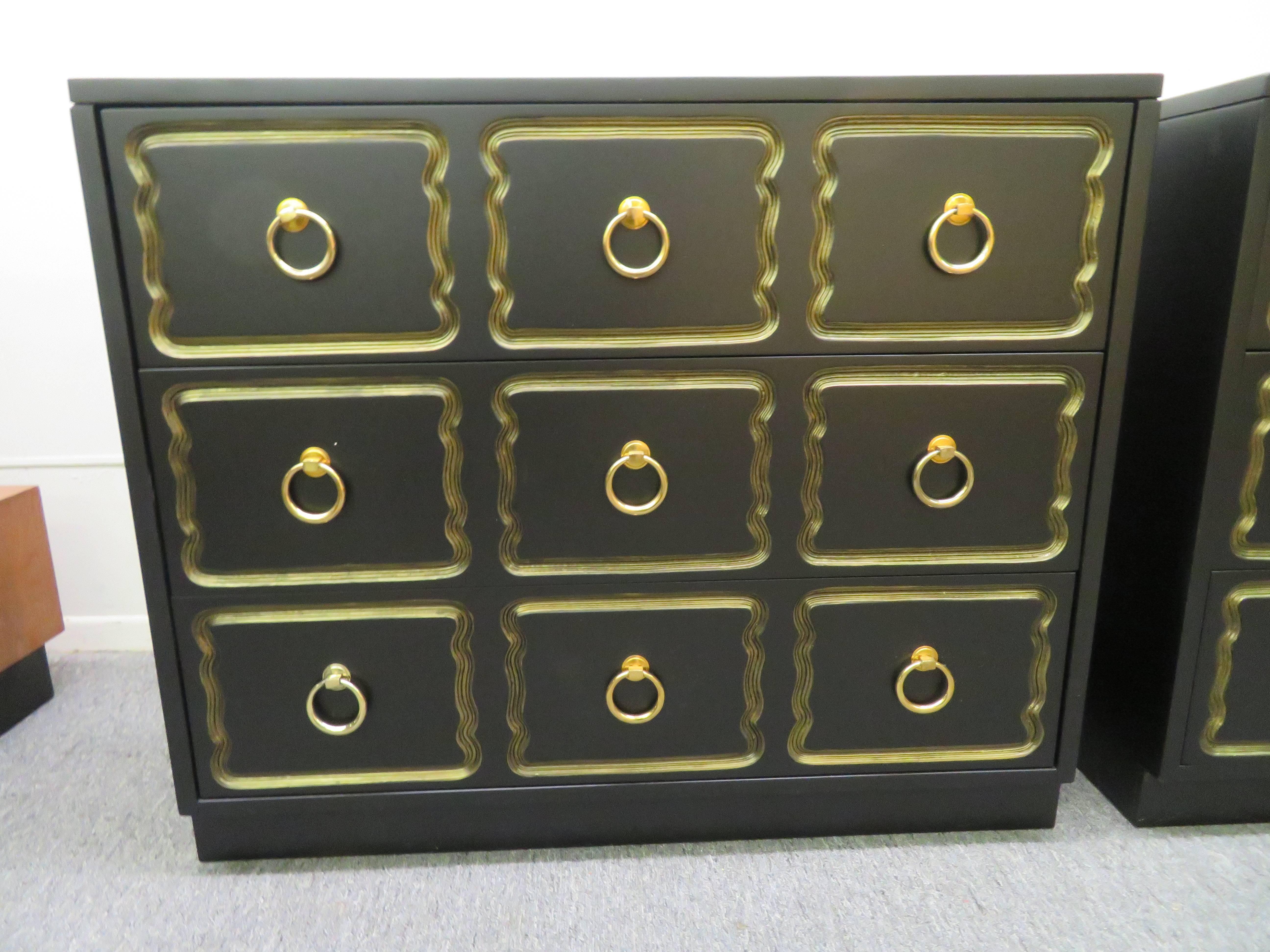 Pair of Dorothy Draper Espana rectangular chests with new black lacquer finish, features three drawers decorated with a repeated routed pattern. Large brass ring pulls adorn the centres of the nine wavy gold rimmed shapes. The low lustre black