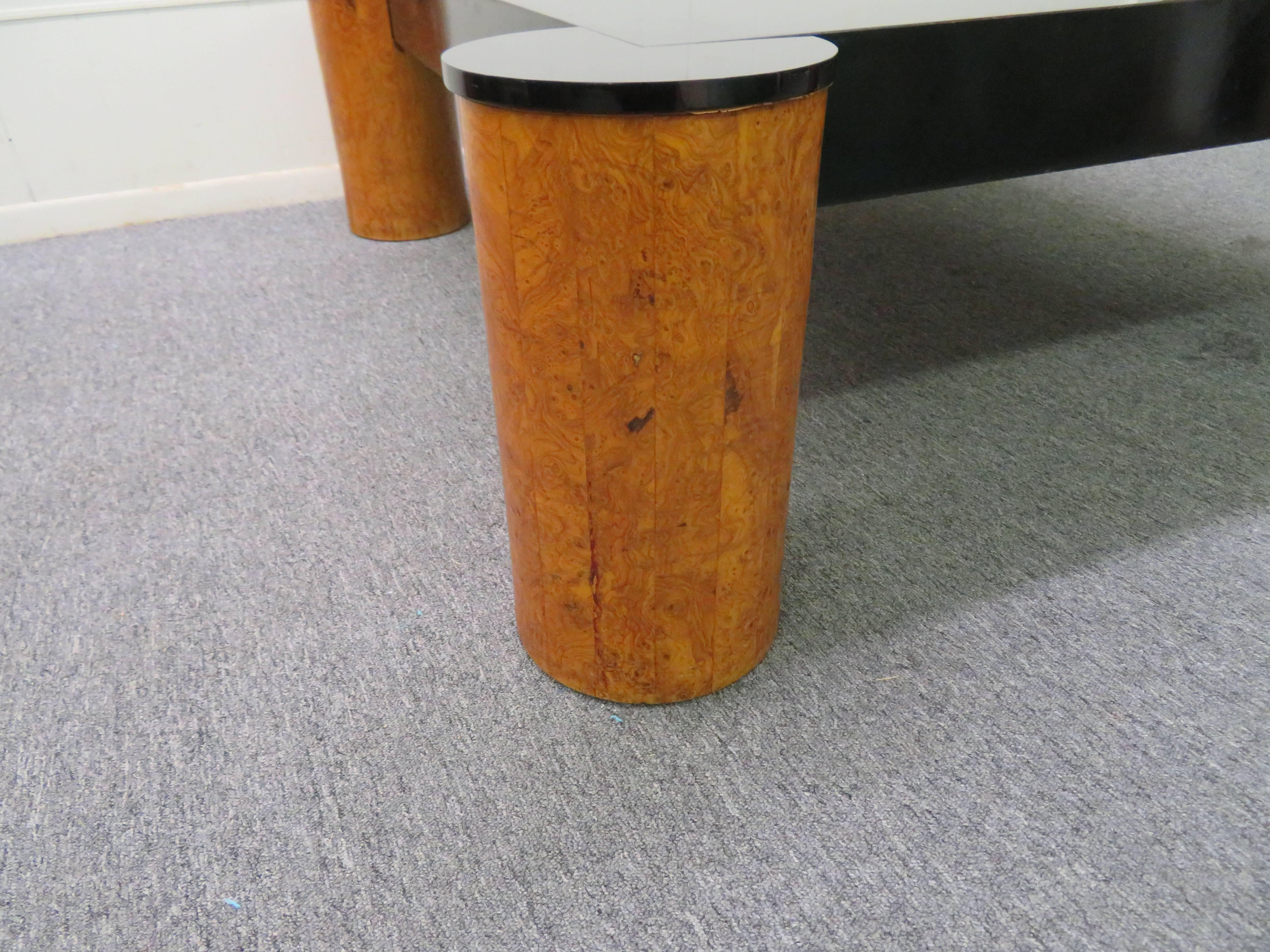 Gorgeous Karl Springer style burled olive wood and black lacquered coffee table. We love the large-scale olive wood cylinder legs in contrast to the black lacquered top.