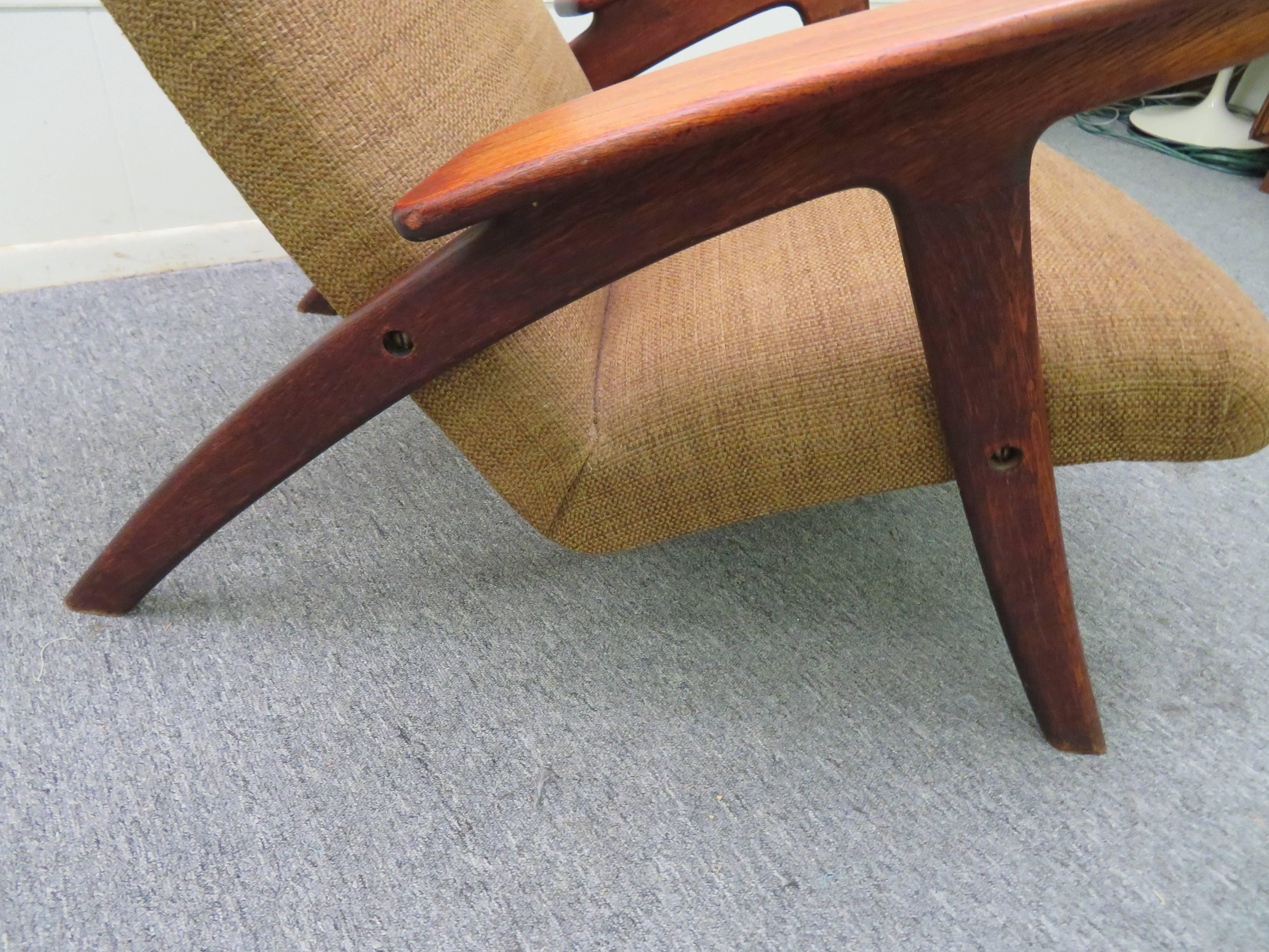 Fantastic Danish modern paddle arm teak lounge chair. This piece retains its original woven textured fabric-a bit dated but still nice. The teak frame has a warm honey brown patina and has great vintage appeal.