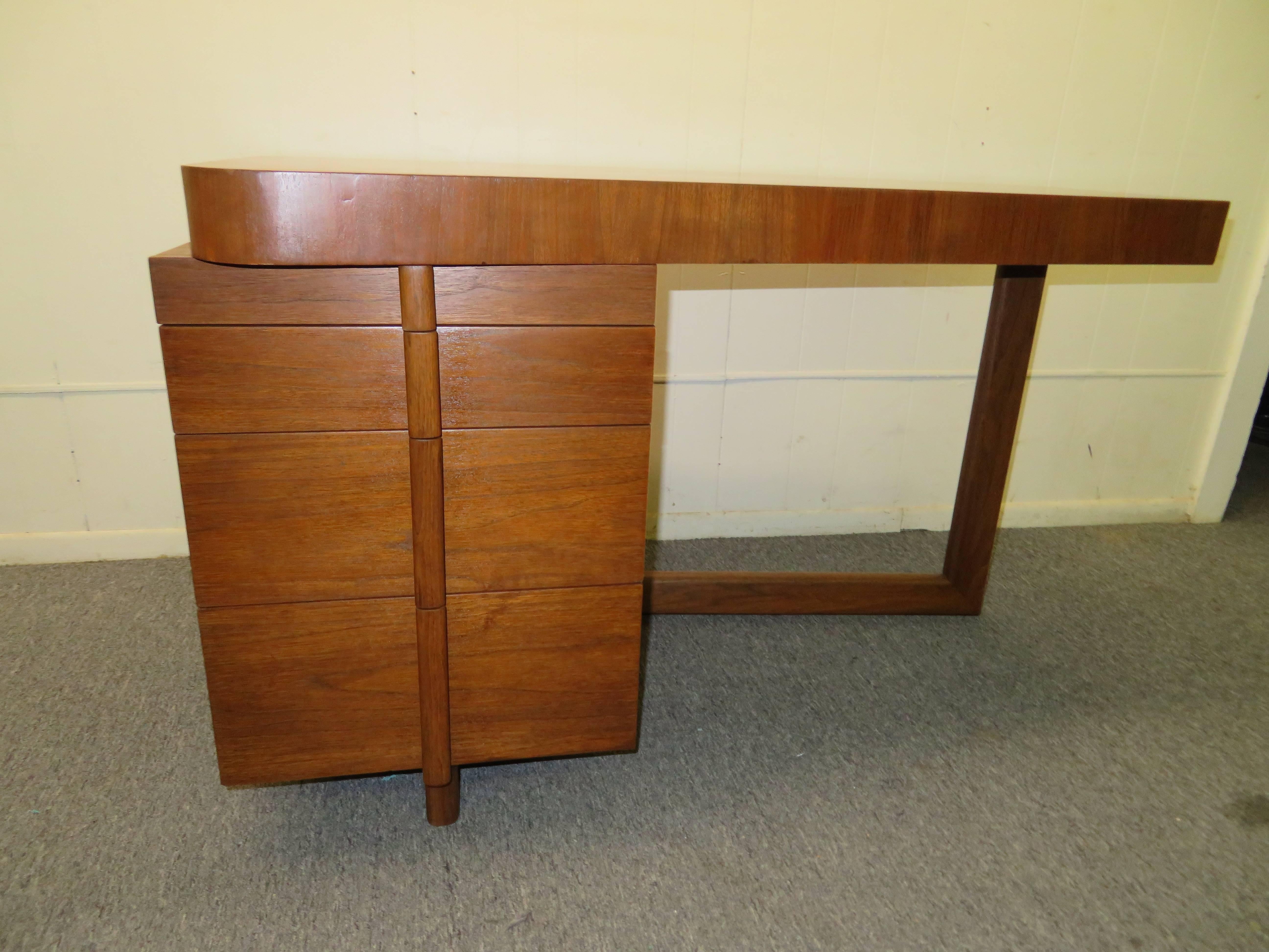 Lovely Gilbert Rohde attributed to asymmetrical top walnut desk. This fabulous 1940s desk has three drawers and a writing shelf, very uniquely designed with wonderful architectural lines. The desk can be placed against a wall or window and can even