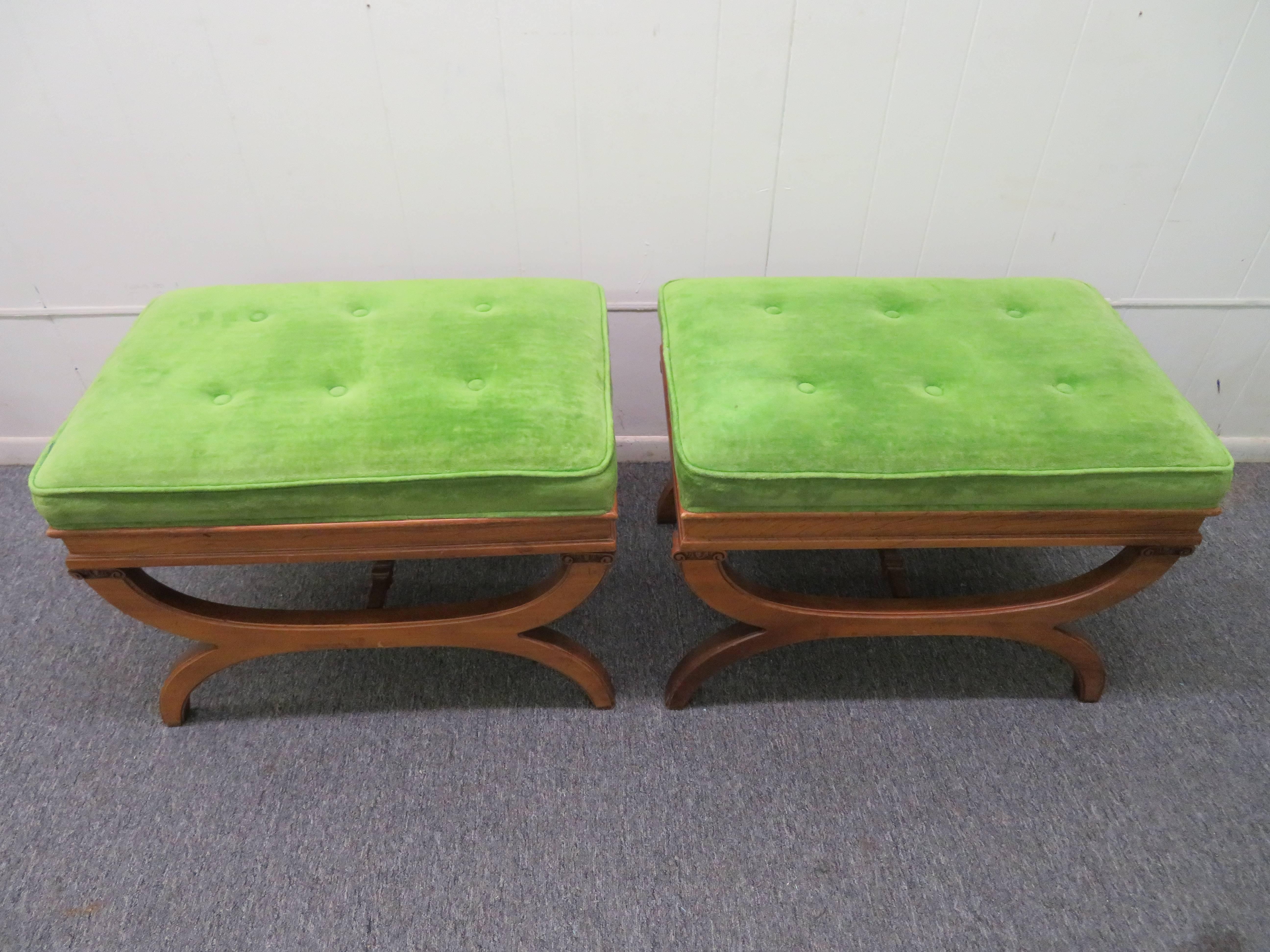 Pair of Hollywood Regency carved walnut X-benches or footstools. This Fine pair of X-benches retain their original velvet fabric in Pantones color of the year Greenery. The beauty of these benches will add timeless character to any area of the home