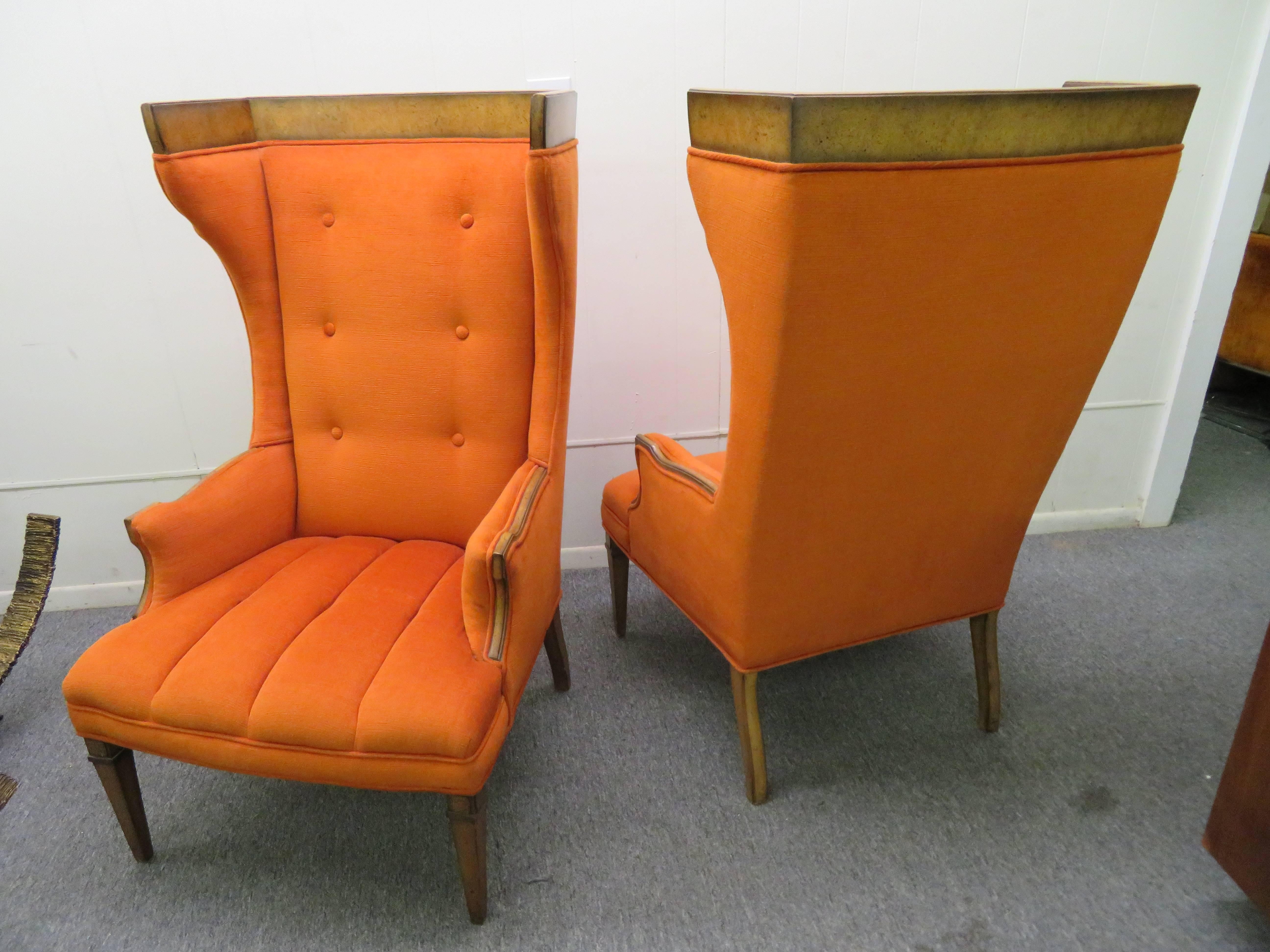Stunning pair of Tomlinson Sophisticate style tall wing back chairs. These chairs have a distressed finish walnut top edge, sculpted arms and legs-great vintage appeal. The original orange fabric still looks great.