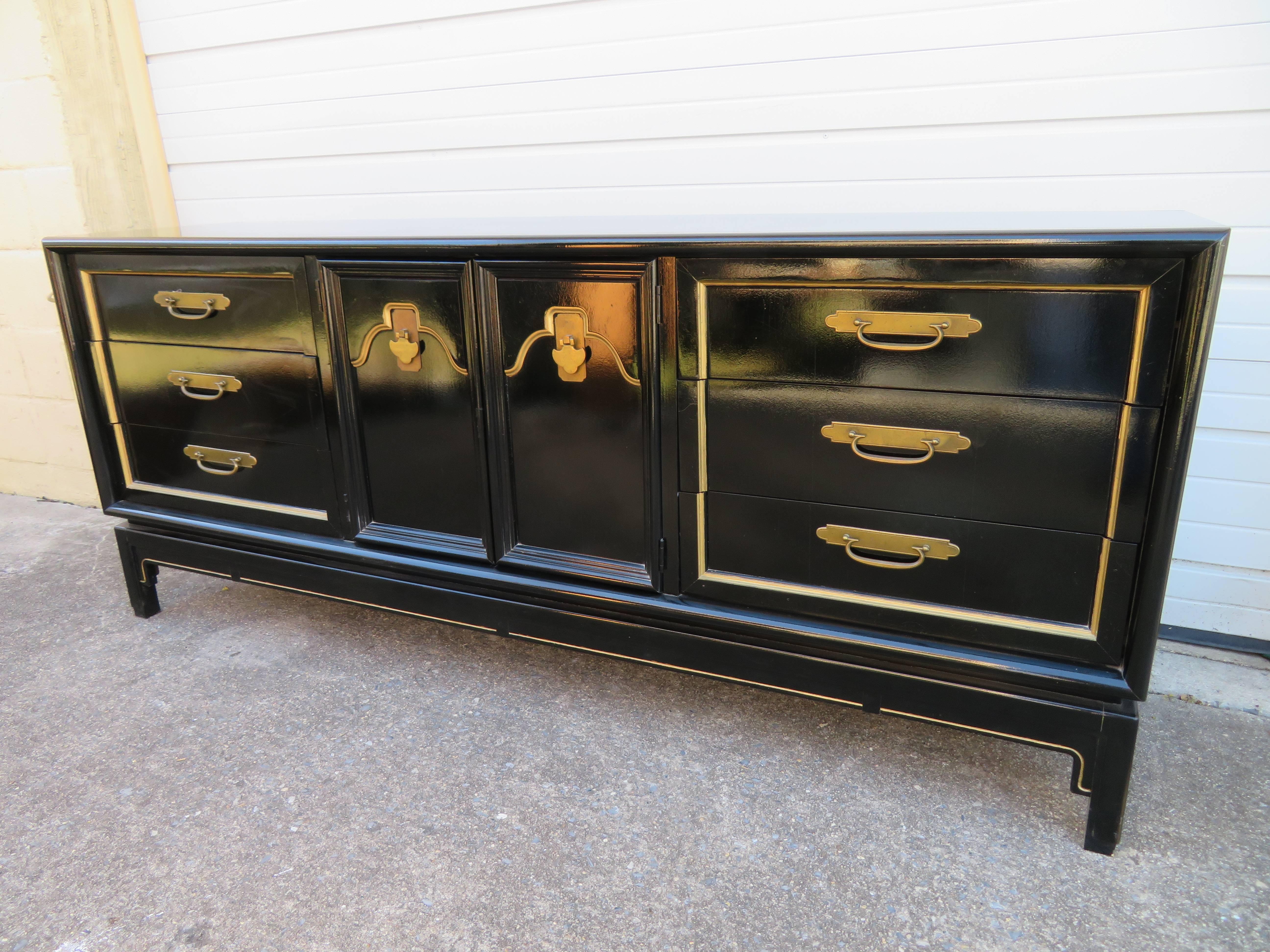 Stunning chinoiserie style black lacquered credenza with brass details. This piece is in wonderful vintage condition, the original lacquer finish still looks great.