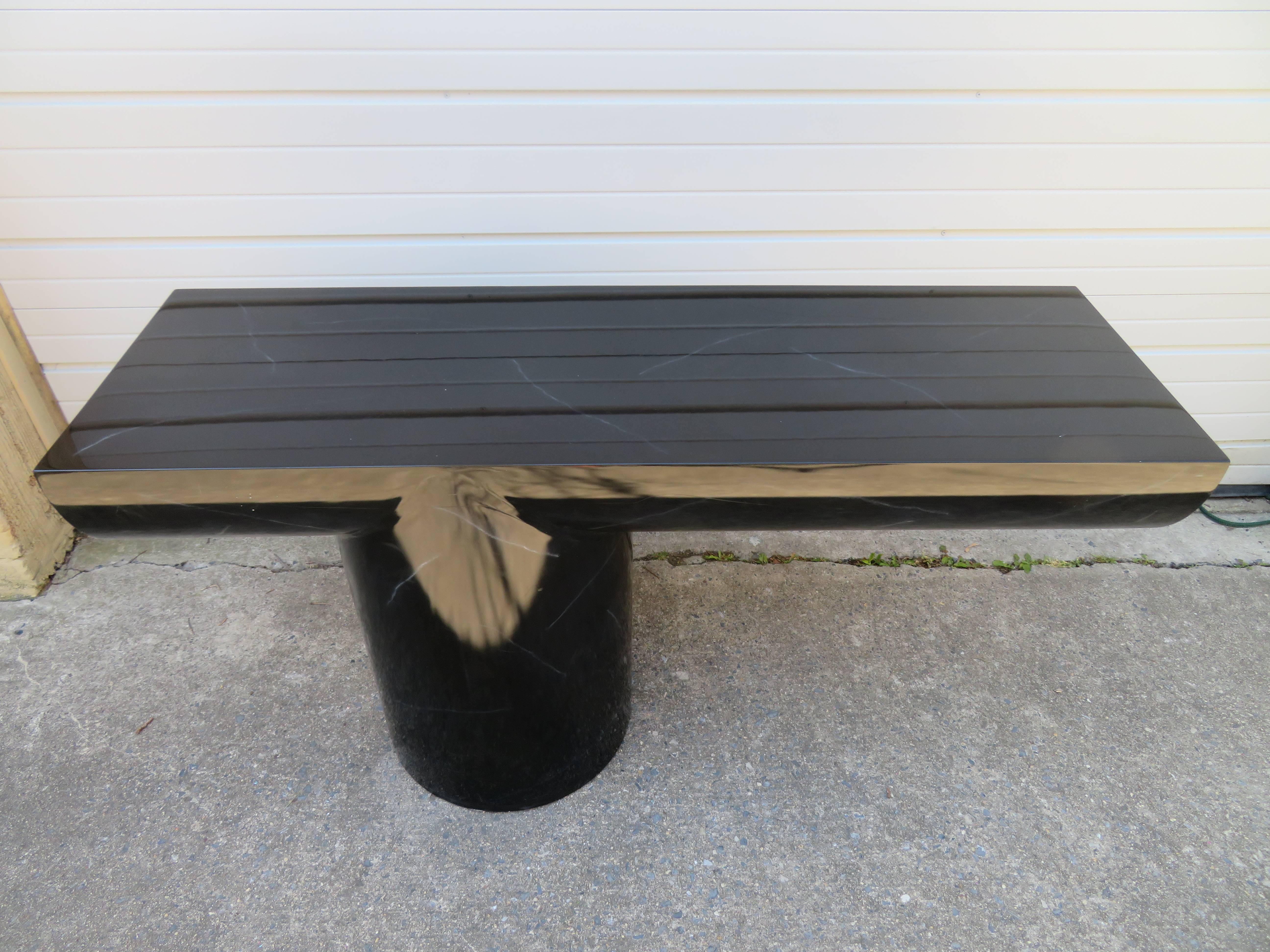 Mid-Century Modern sculptural black lacquered console, sofa or hall table featuring sleek and sexy cantilever design. Asymmetrical design features thick tubular and half cylindrical shapes in the original glossy faux marble black finish.