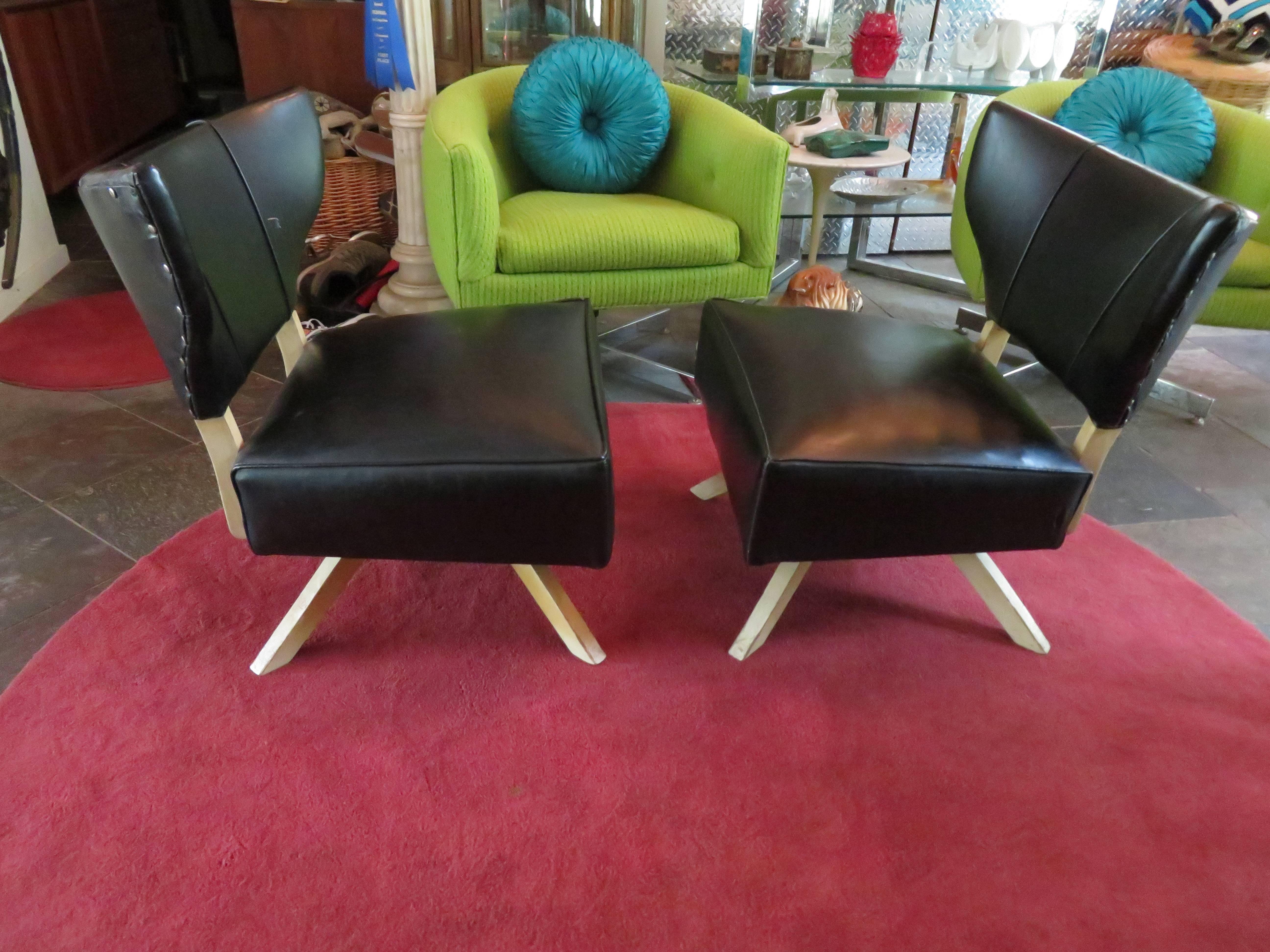 Super cool pair of Kroehler bat wing swivel slipper chairs. The chairs are in nice vintage condition and retain their original black faux leather-reupholstery is recommended. We love the outrageous bat wing style backs with the extra wide seats and