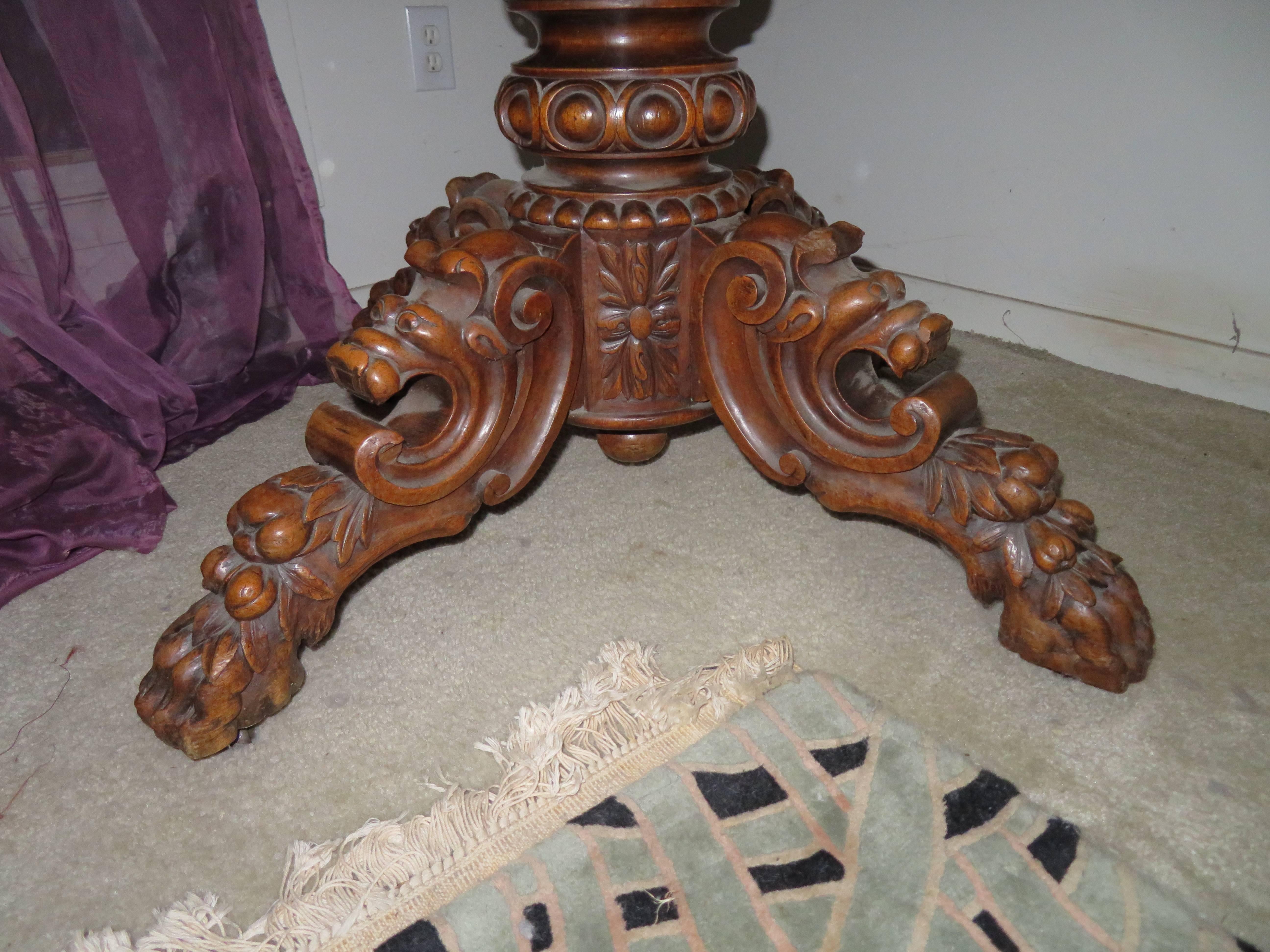 Absolutely stunning antique French carved griffin oval dining table. Massive carved pedestal base supported by ornate hand-carved dimensional griffins on all four legs with a lovely pecan wood top. The oval tabletop is gorgeous with lovely carved
