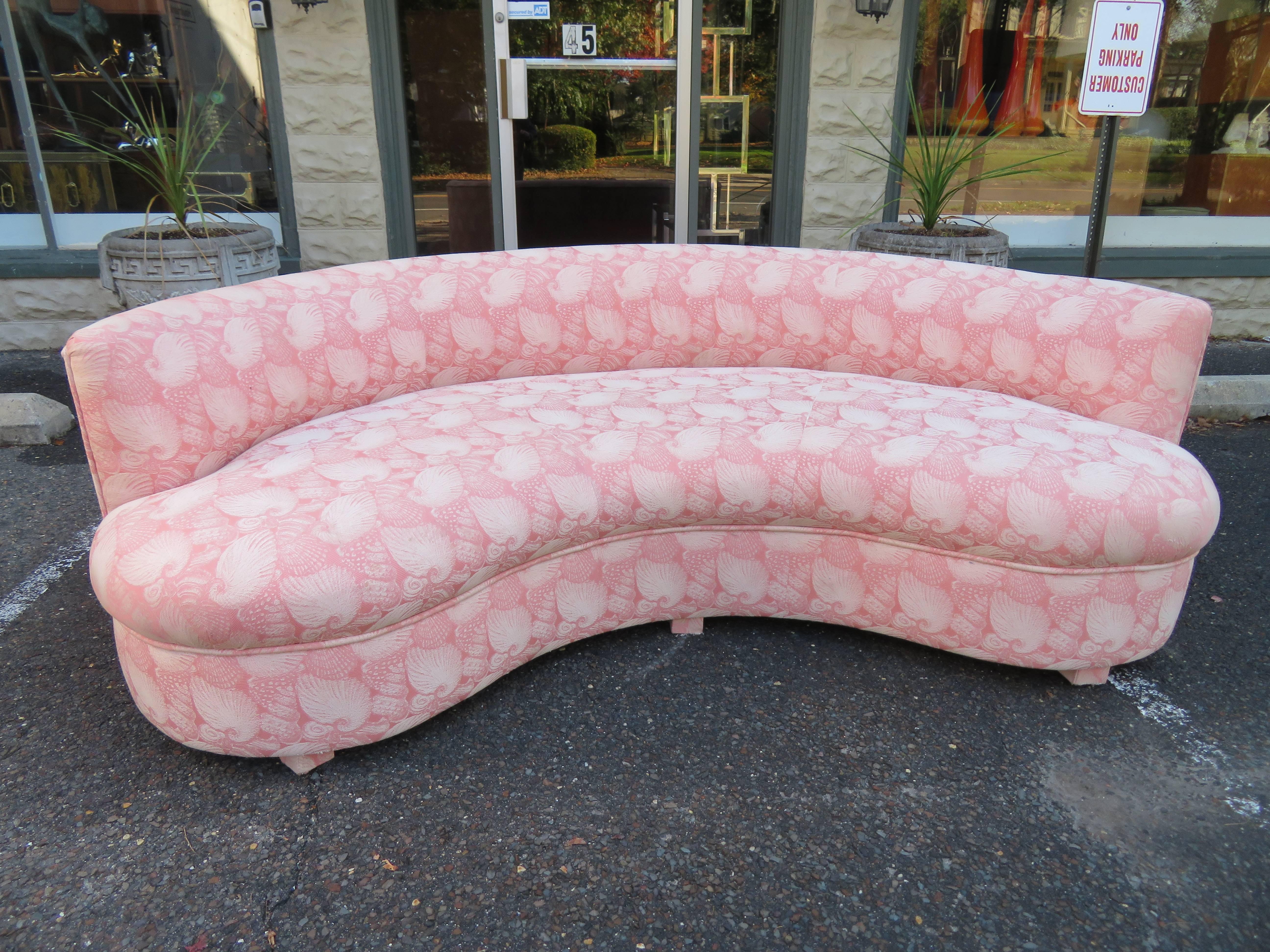Stunning pair of Vladimir Kagan style curved kidney shaped sofas. The original pink sea shell fabric still looks nice but is a bit dated-reupholstery is recommended.