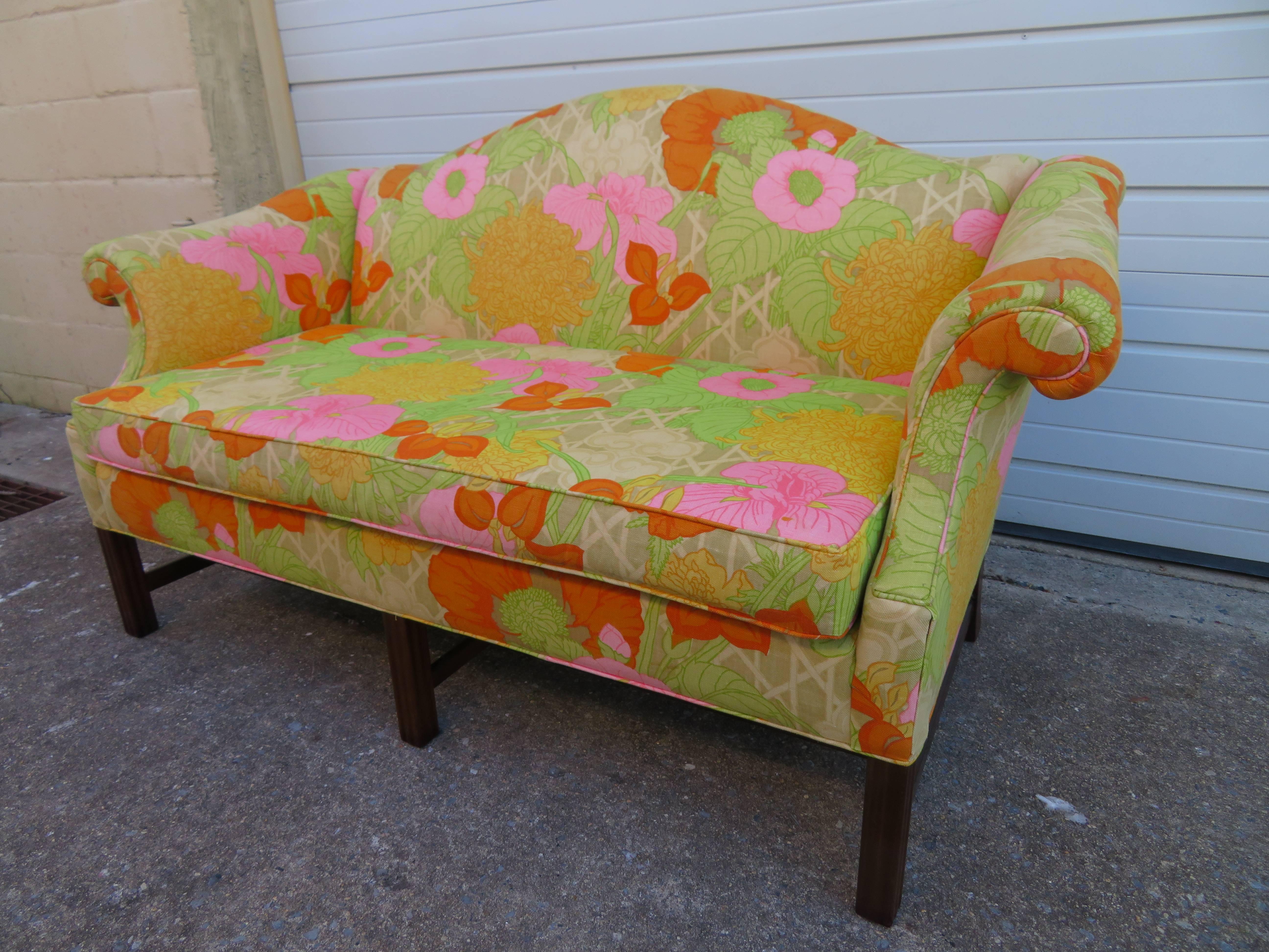 Wonderful flowered linen Chippendale style camelback loveseat sofa with mahogany legs.  We love the original bright flowered linen used on this sofa-gives it great vintage appeal.