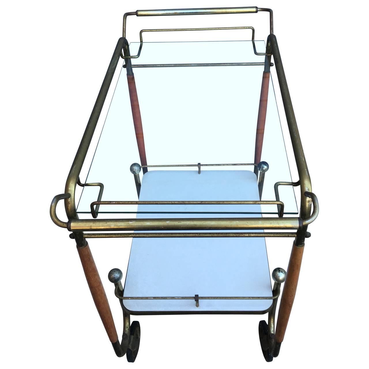 Mid-Century Modern brass and walnut two-tier bar cart.
Oh, this is a beauty! The warmth of the wood combined with the brass make this bar trolley a real statement piece. The glass shelves are ready to hold your bottles and mod glassware. On original