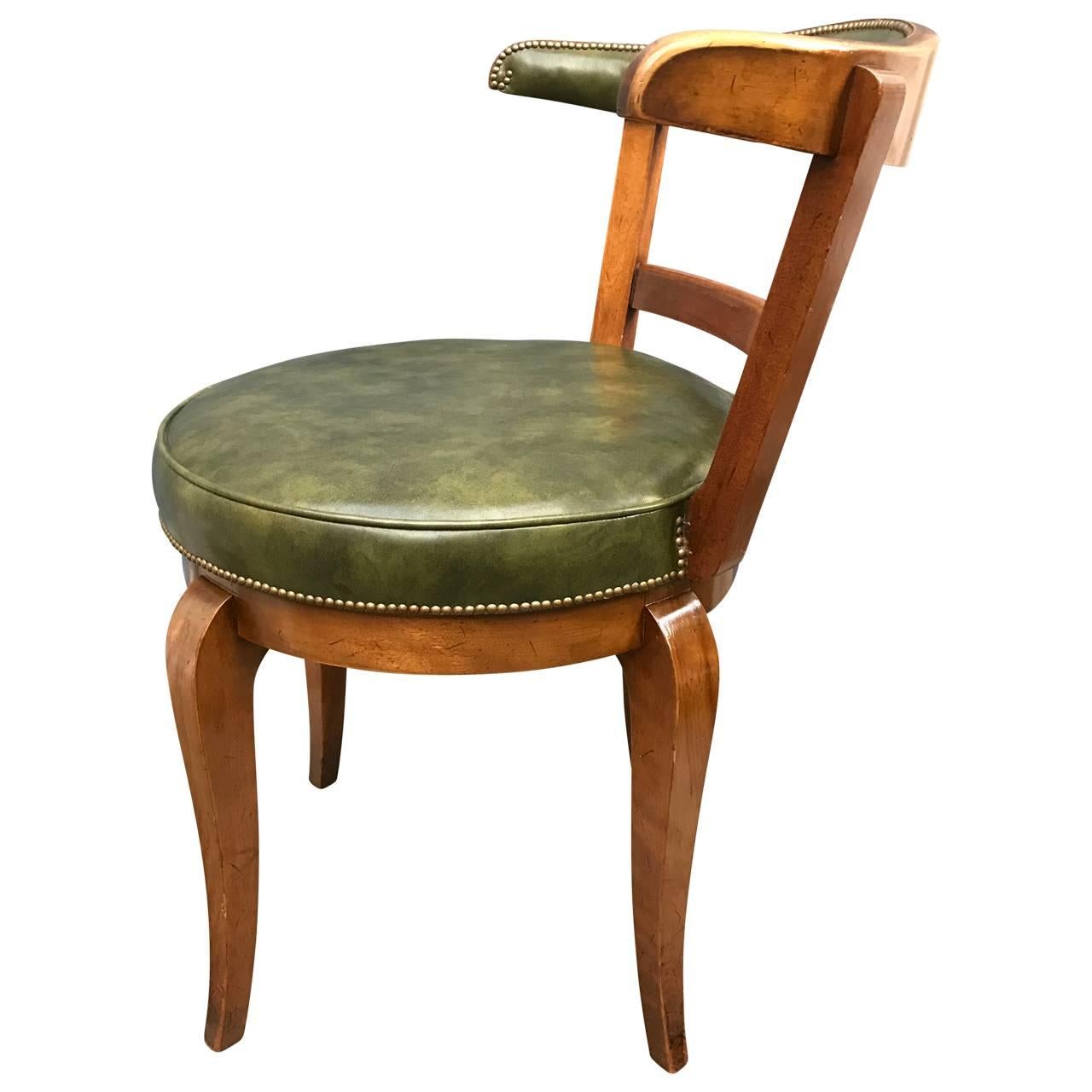 Lazy Susan horseshoe vanity chair in green leather and nail heads.