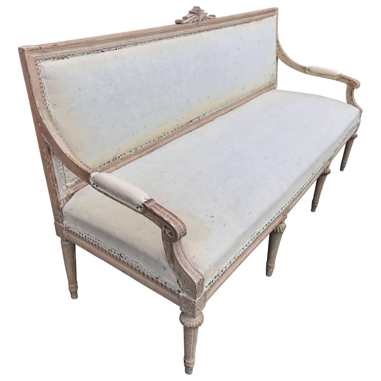 Large Gustavian sofa with rectangular back, carved moldings and on circular tapered legs. 
