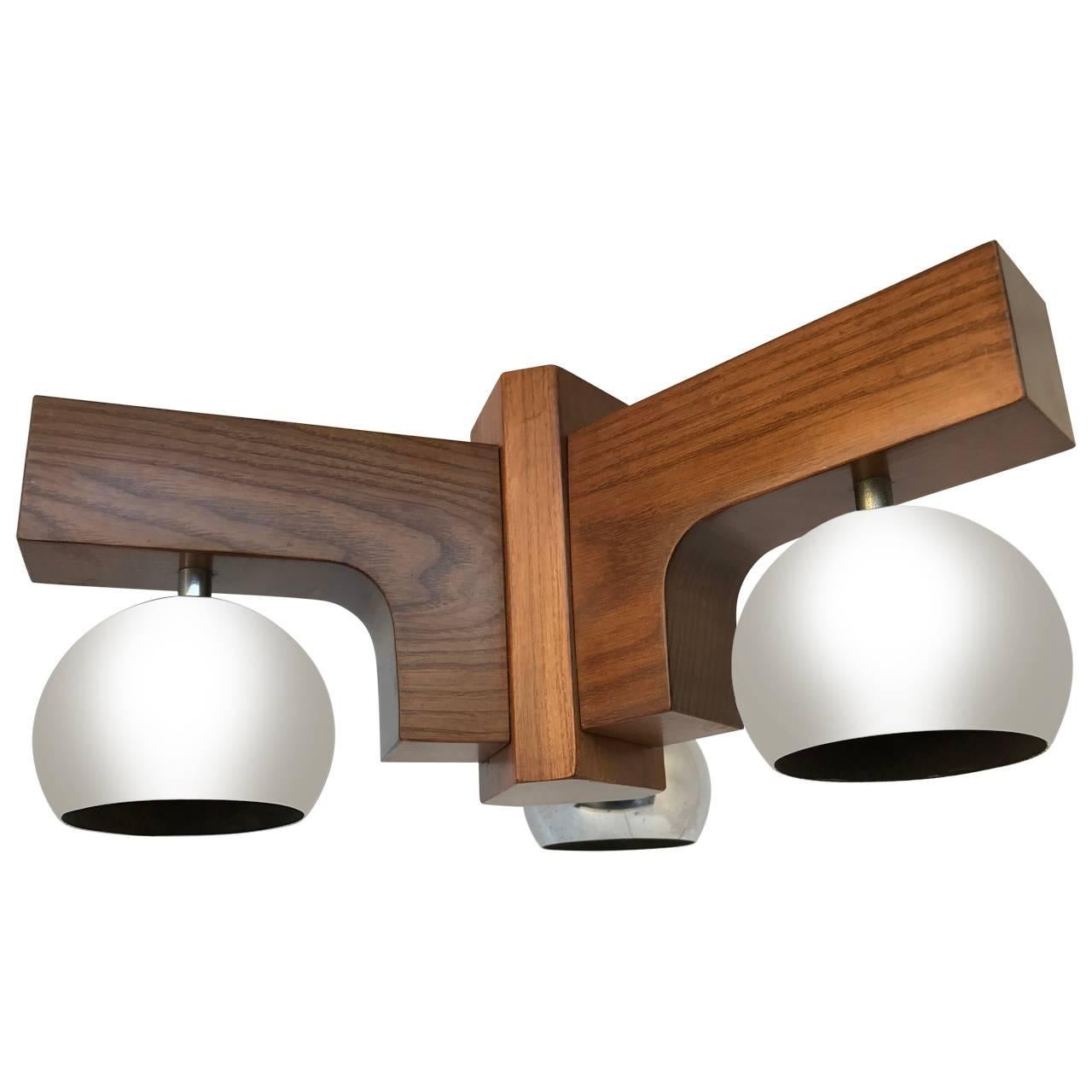 Mid-Century Modern Italian ceiling fixture chandelier wood and brushed chrome globes.
Small Italian three-globe light fixture. The wooden frame with brushed chrome globes is an excellent choice for a modern decor. The chandelier will emit a warm
