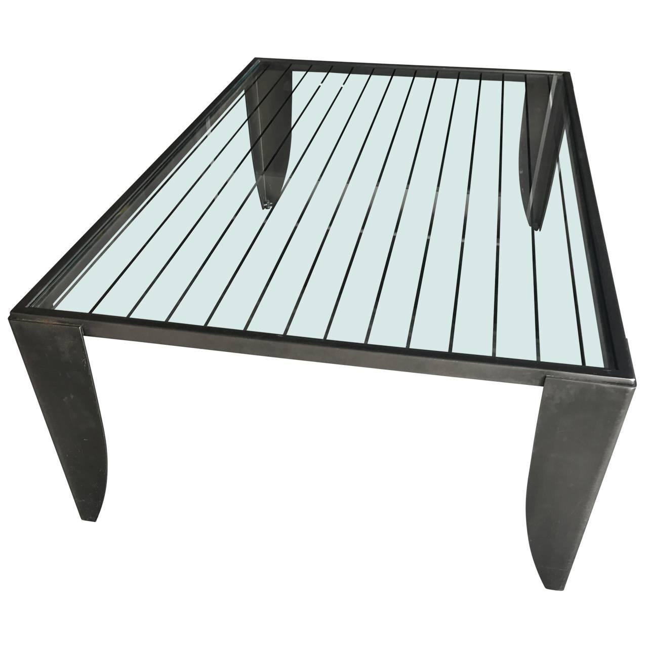 Sleek cocktail table in brushed steel and glass top. Glass top has several etched silvered lines.
