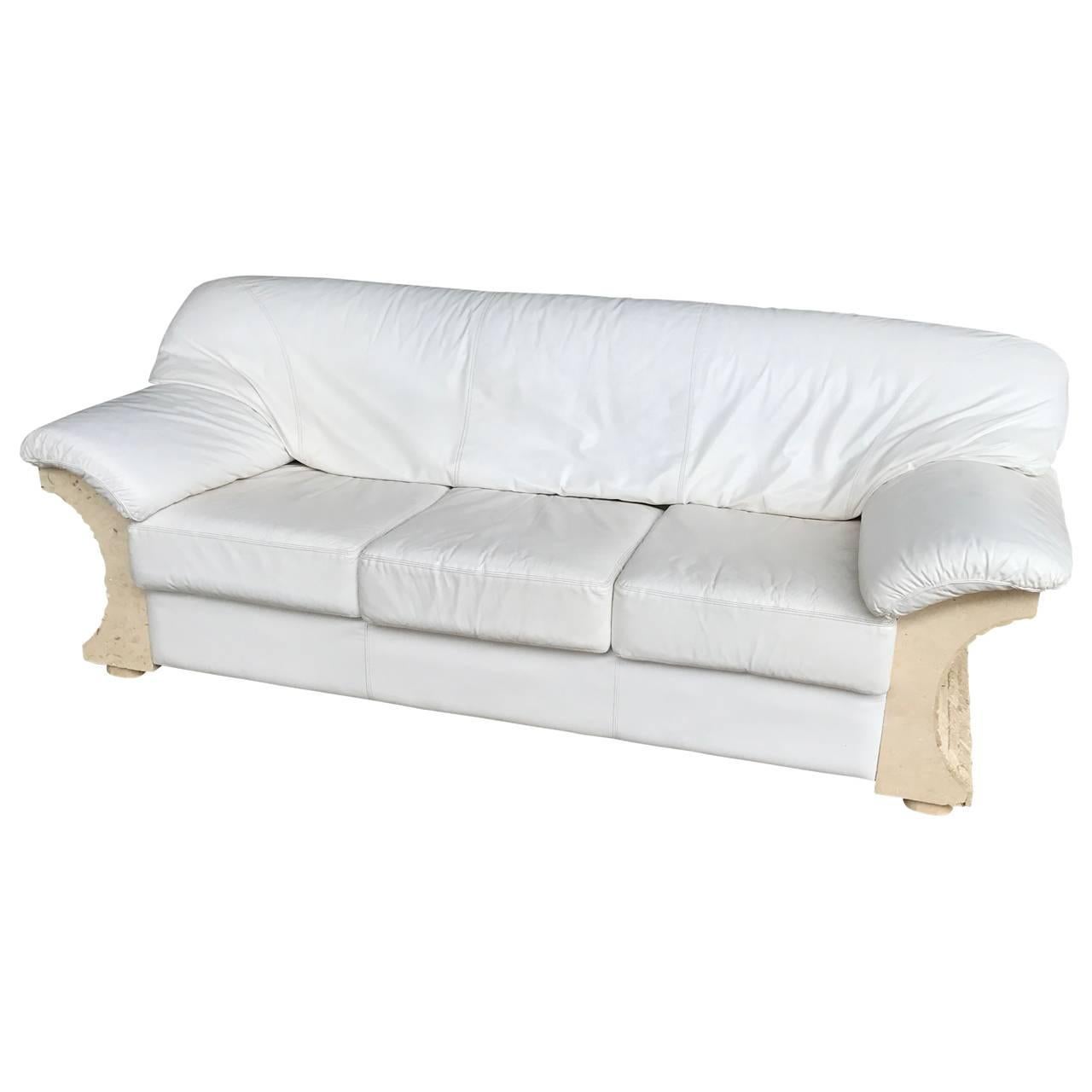 High quality three-person sofa with tessellated marble veneer and rough brick-like sides. The thick white leather pillows are secured with velcro stripes.