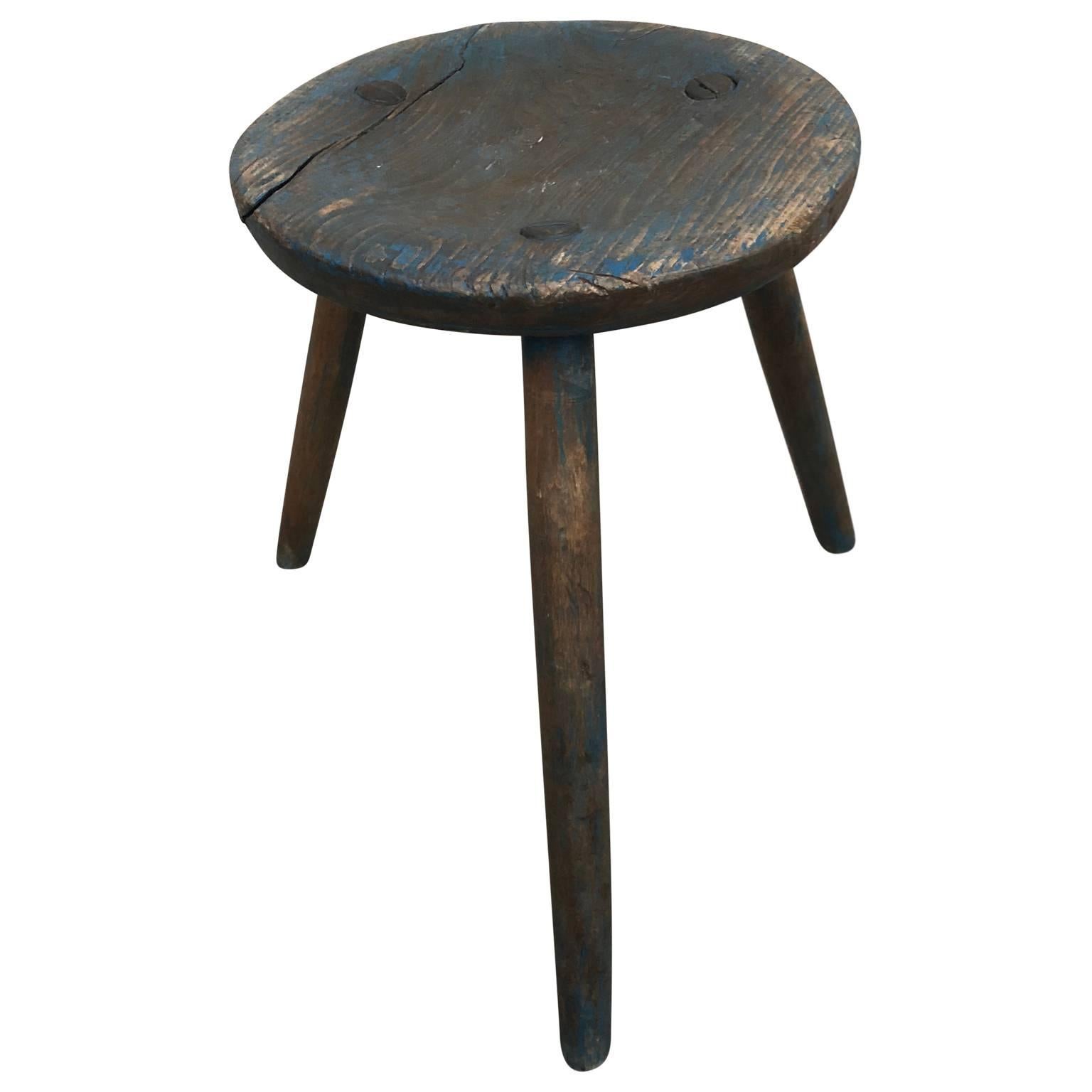 Three-legged stool with remnants of the original Gustavian blue paint. Stool has a old charming metal repair to enhance the strength, it is in good sturdy and working condition.