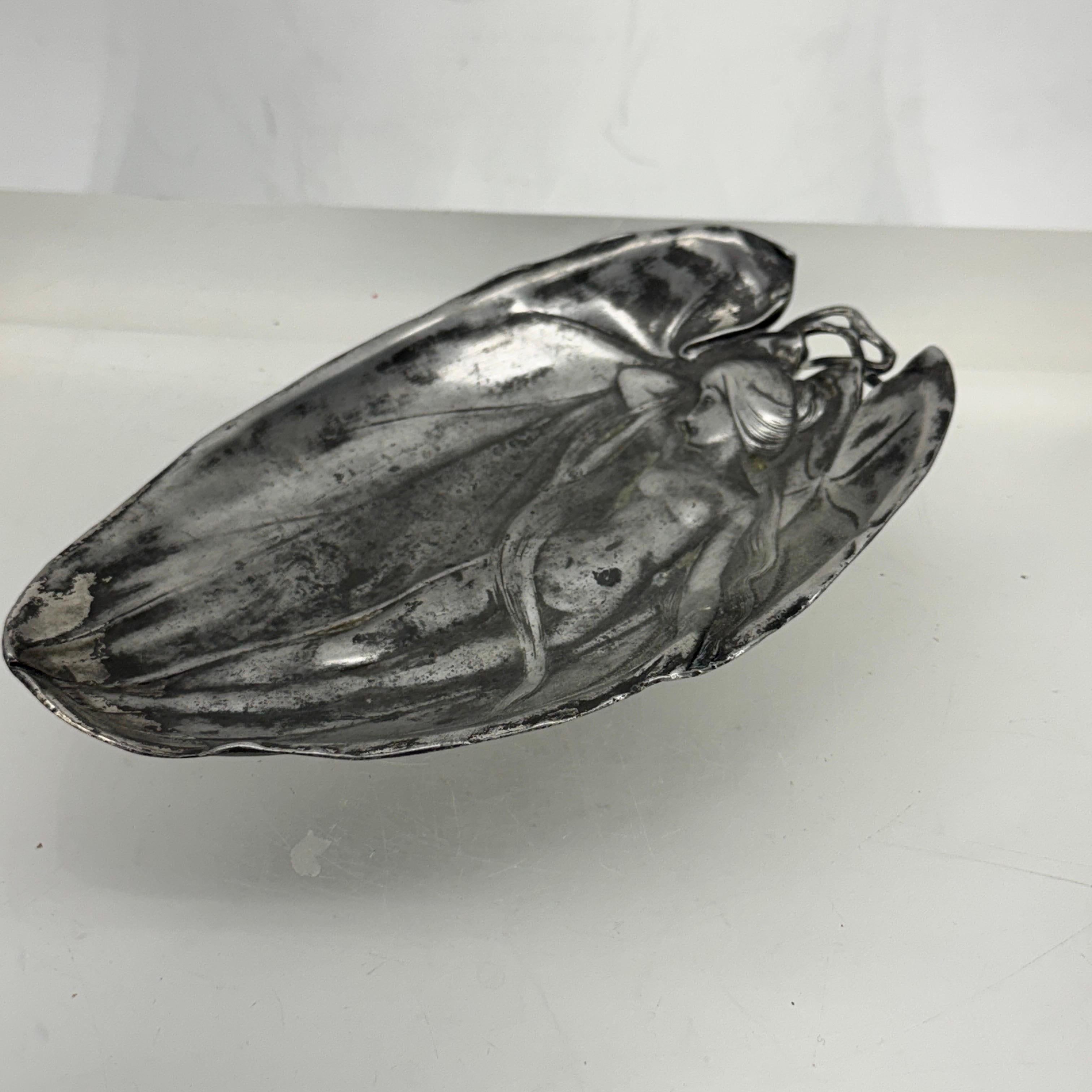 This small French tray is decorated in the typical styles of this Art Nouveau period featuring a nude woman posing. The condition of the tray is sturdy and has an amazing warm and charming appearance.


