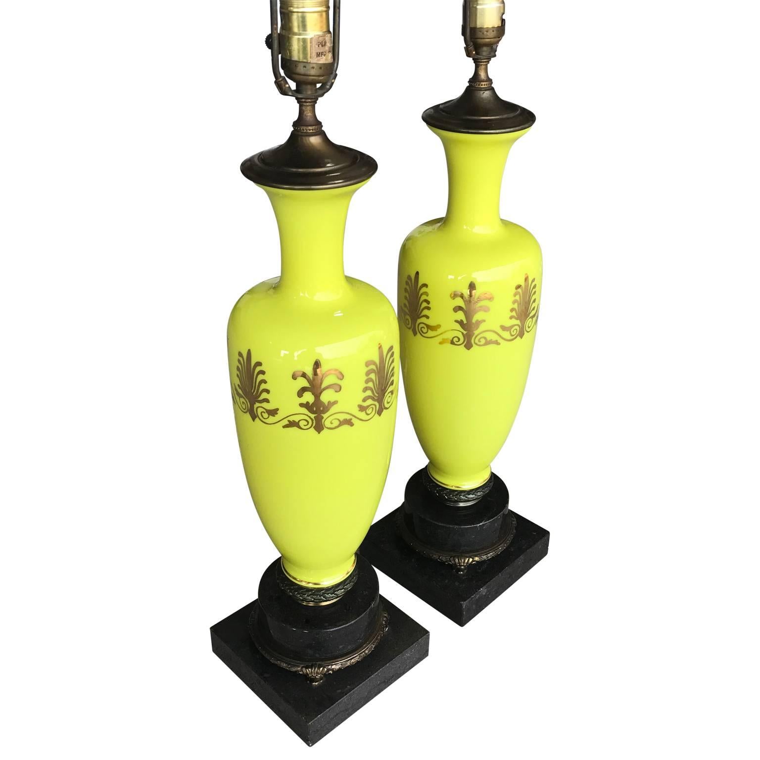 Pair of opaline lamps in an amazing chartreuse yellow on a bronze decorated marble base. The opaline glass is decorated with a continuous
band of gilded fleur-de-lis.
Height to top of harp is 32.5 inches.