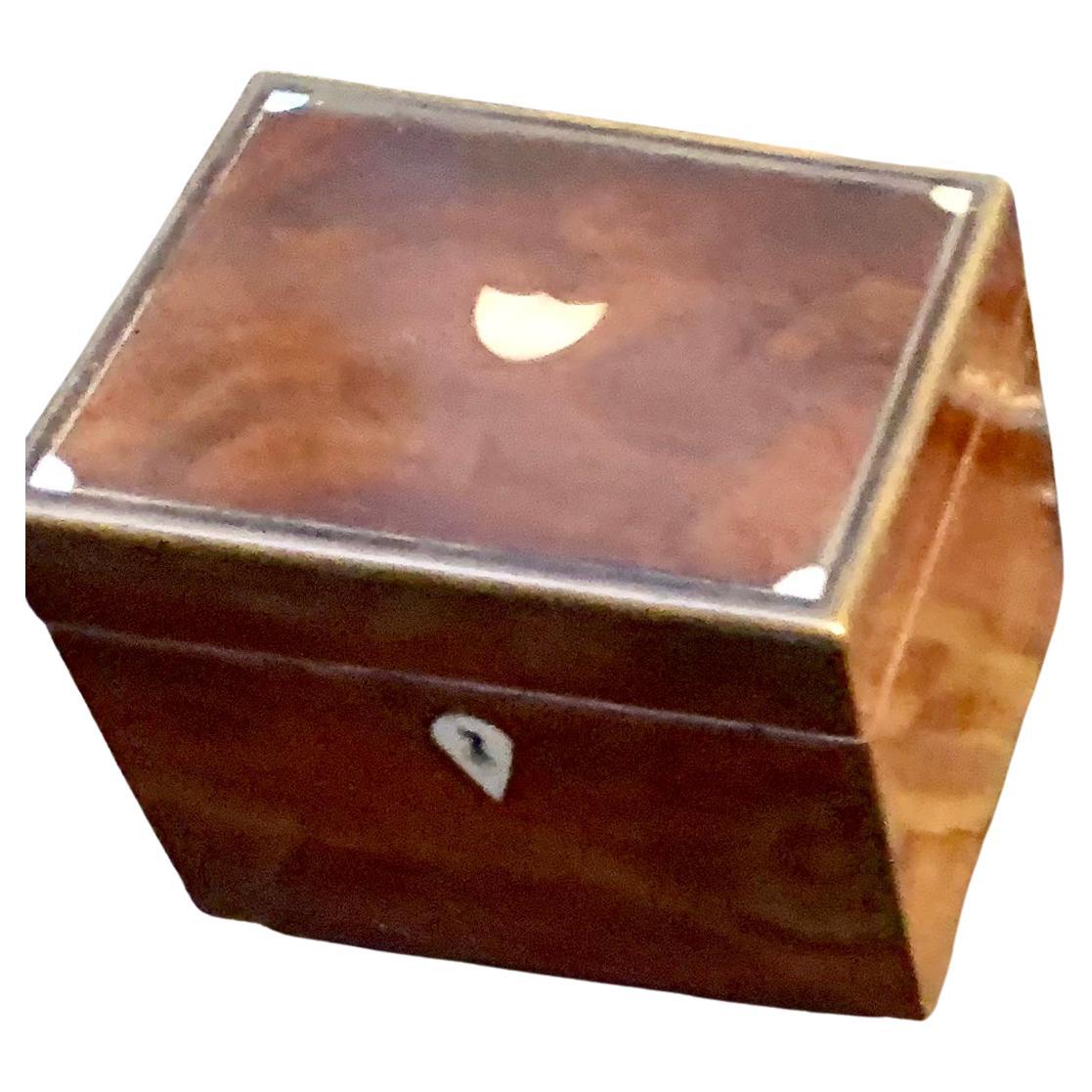 Mahogany box with inlaid mother of pearl and mirror, on small round brass feet.