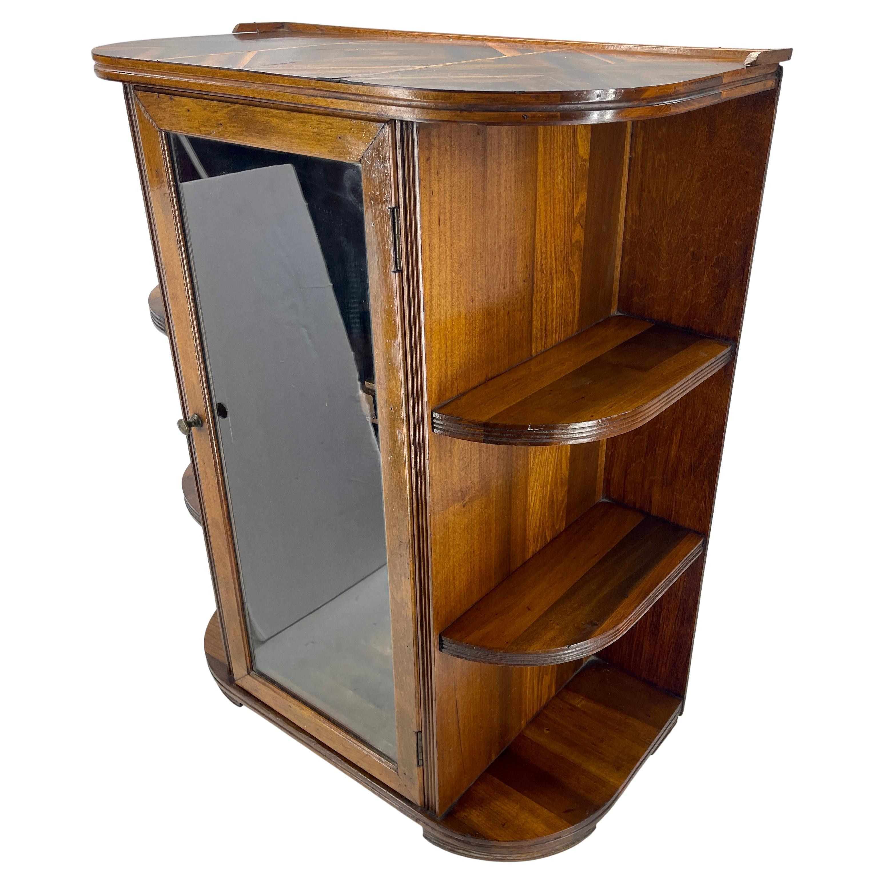 Art Deco bar with walnut and glass front cabinet. This compact bar from 1930's Germany is as beautiful as it is practical. The top of the bar is with inlay fruitwood. The sides have softly curved shelves to hold glasses or bottles. The bar sits on