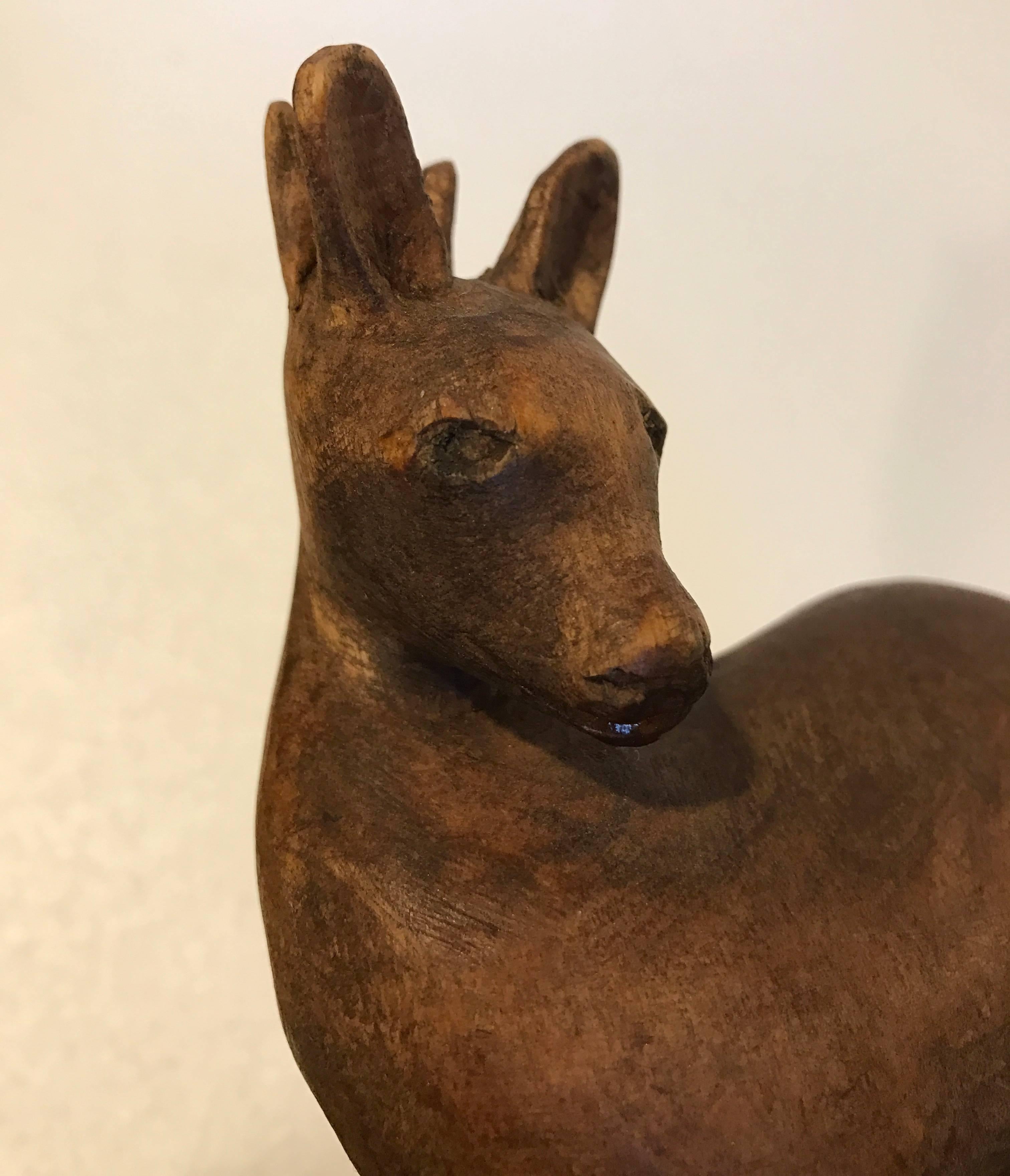 Small wooden deer sculpture.
