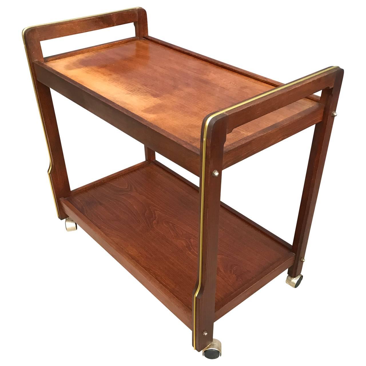 Mid-Century Danish bar cart with plastic covered brass decorations. Top tray has sun related discoloration which appears to be a charming addition to a Classic Mid-Century design.