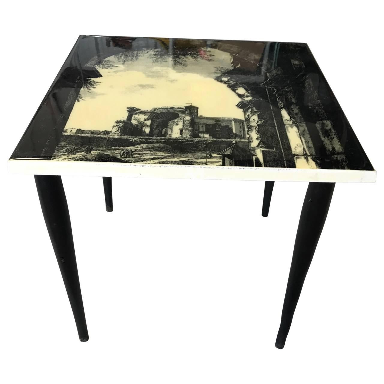Fornasetti style Mid-Century Modern side table. This petite Italian end table bears a lovely lithographed laminated scene of a rural Italian countryside. The table has beautiful classical Italian Mid-Century Modern styling; black legs, white trim