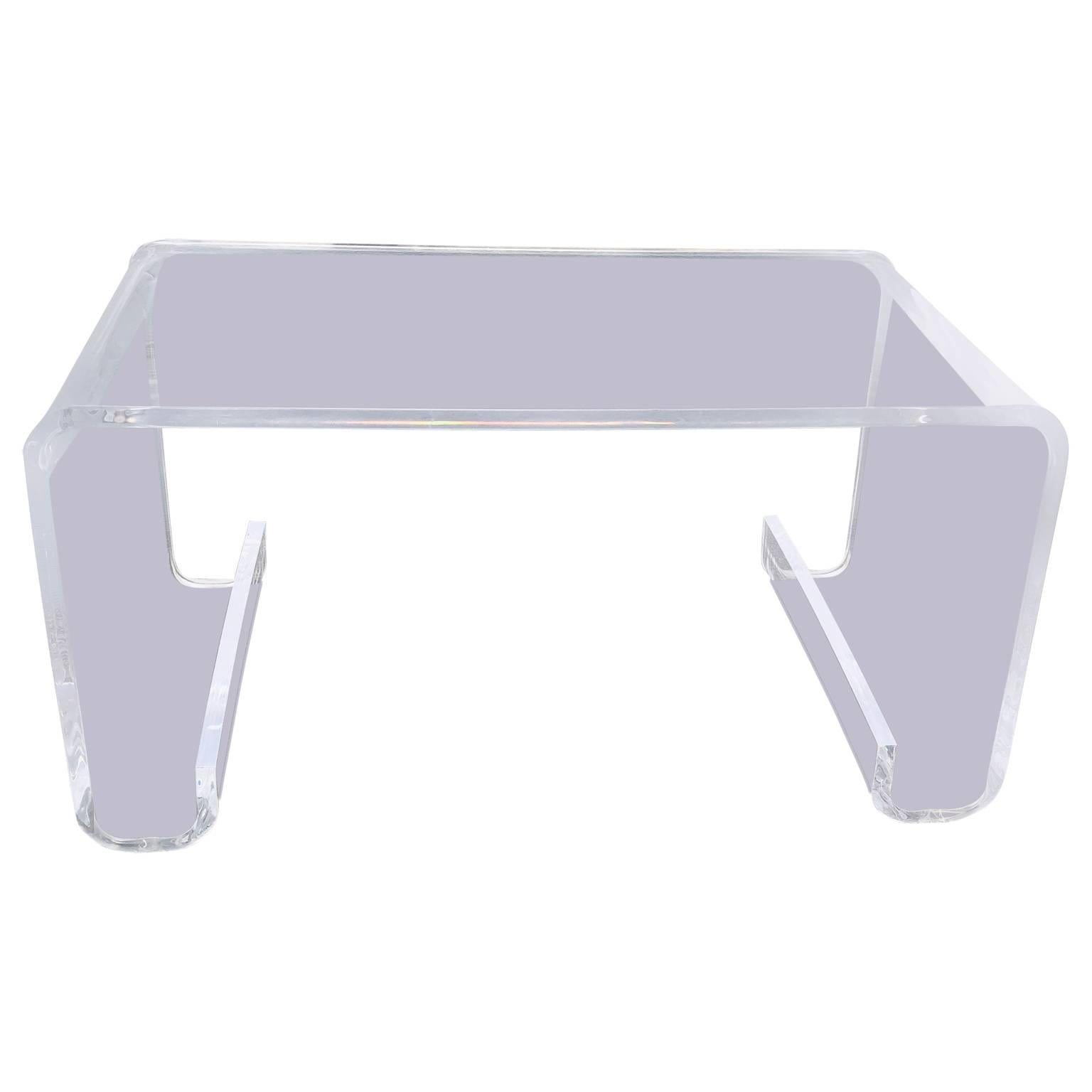 Lucite waterfall cocktail table in the manner of Hollis Jones. This exquisite rectangular Mid-Century Modern table sports thick lucite. The table is sturdy and will make a wonderful addition to a modern decor. 



 