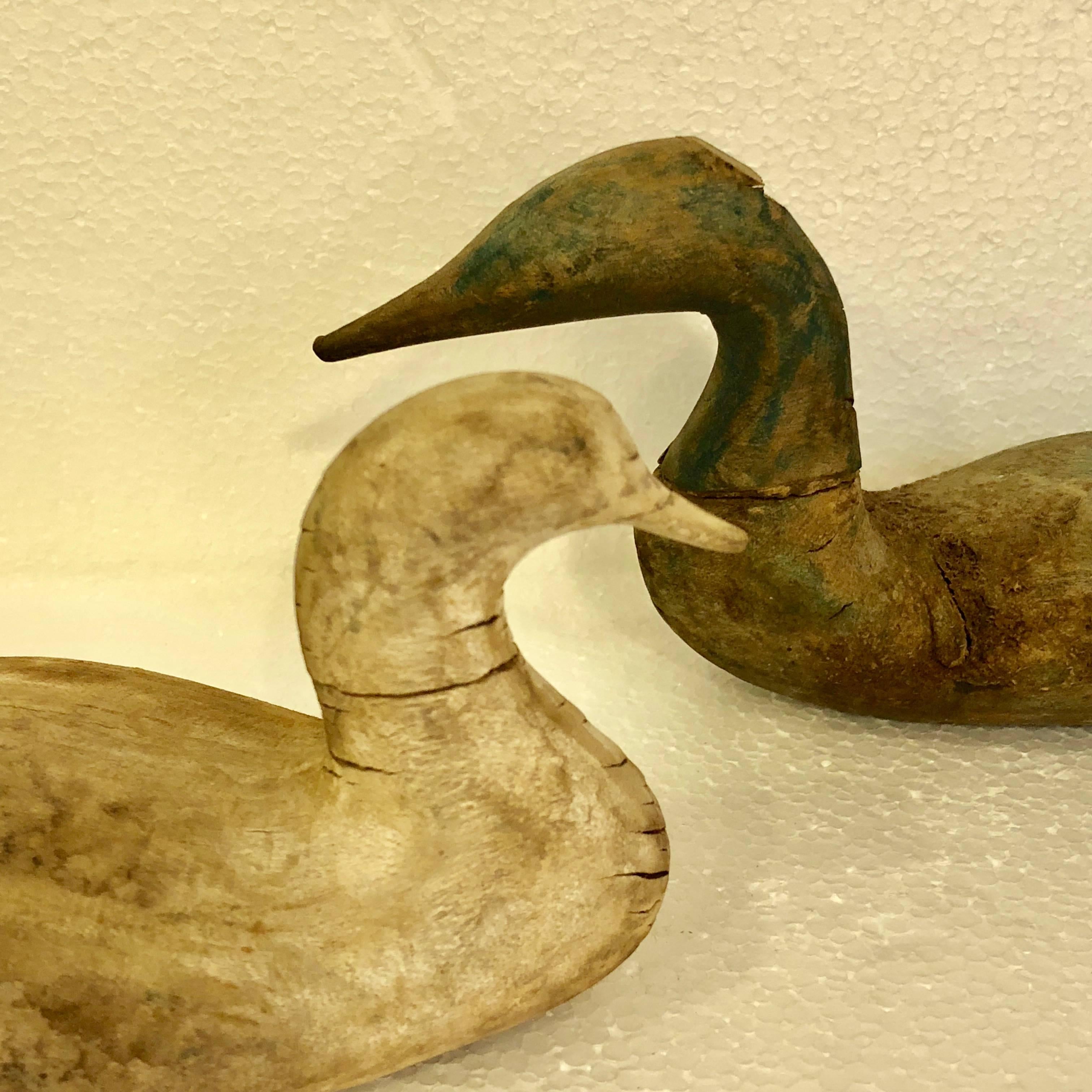 Two Scandinavian 19th Century Hand-Carved Folk Art Duck Decoys

The lighter colored duck measures: D 3.25, W 7 and H 3.25 inches
The darker one was originally mounted and has a broken off stick on the belly side, see detailed images.
This darker