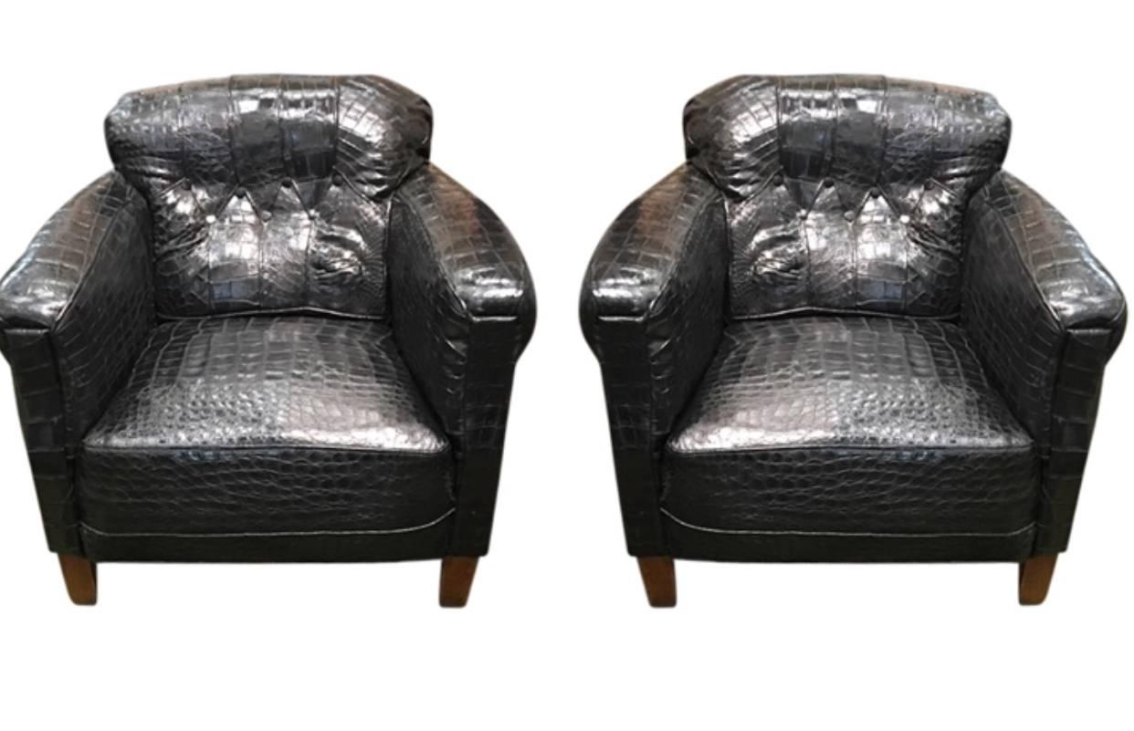 Pair Of French Art Deco Framed Black Enhanced Alligator Upholstered Lounge Chairs. Both chairs has period brass hardware wheels on the front legs