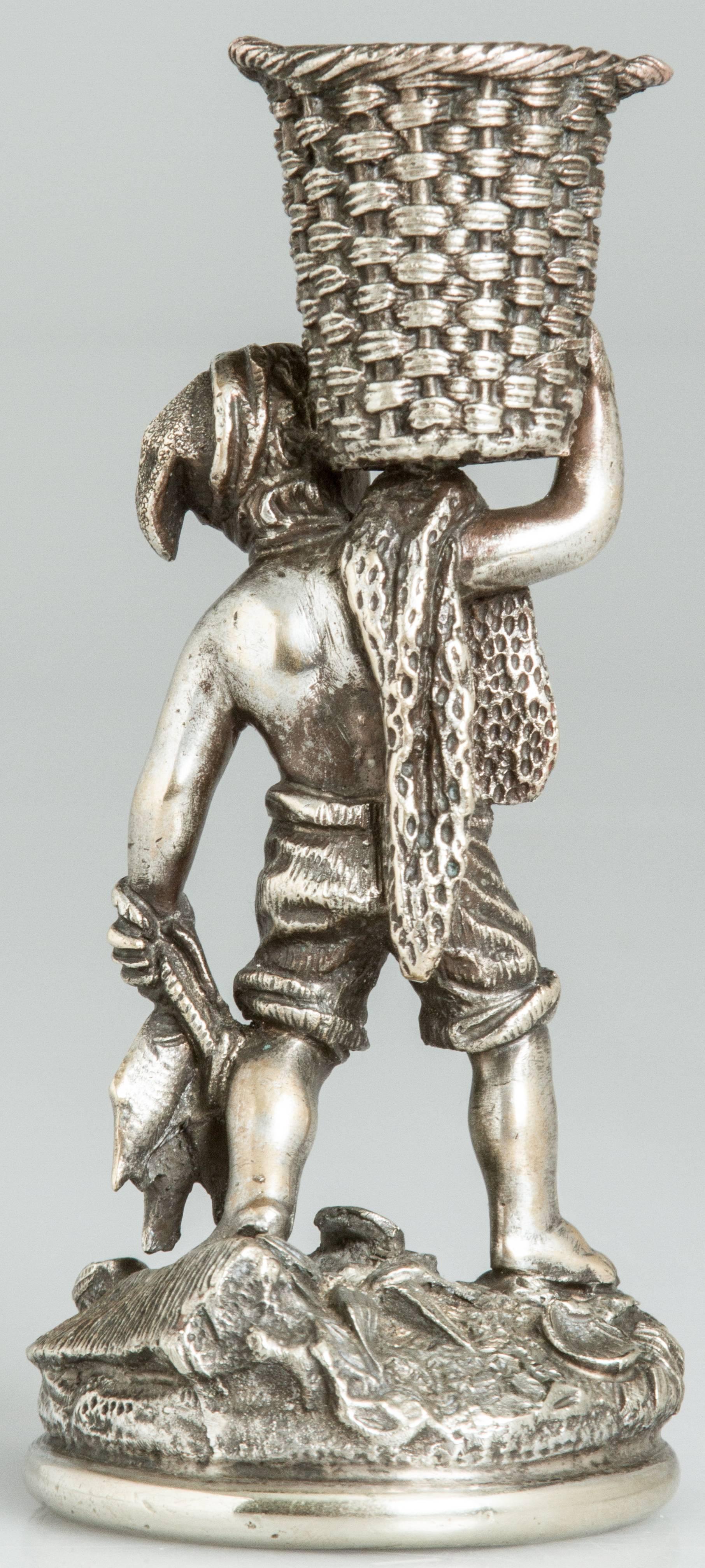 A young fisherman with a basket atop his head is holding a string of fish with various shells at his feet.
The basket holds the matches and the striker is on the base.