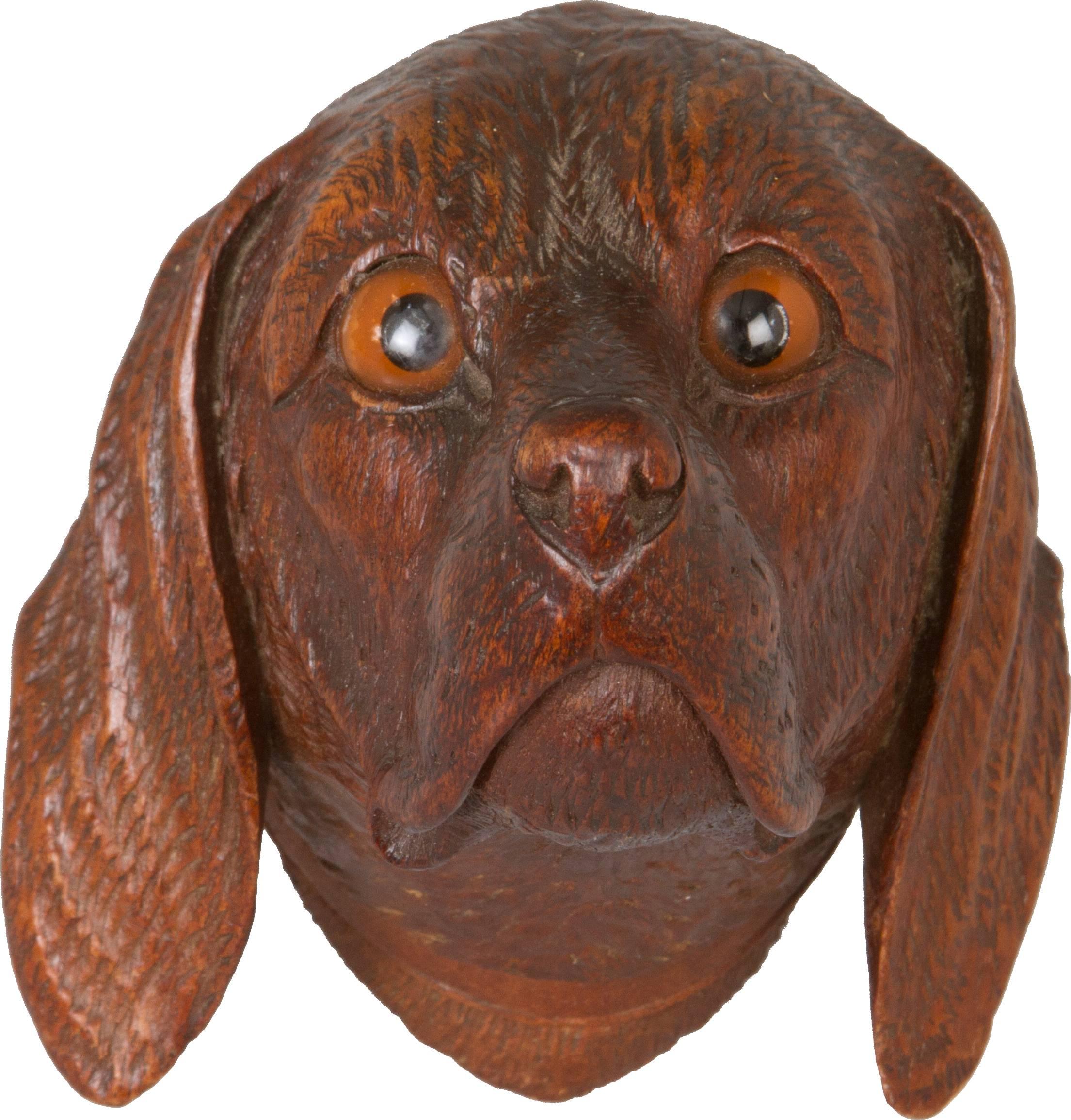 Beautifully carved this dog has amber colored glass eyes.