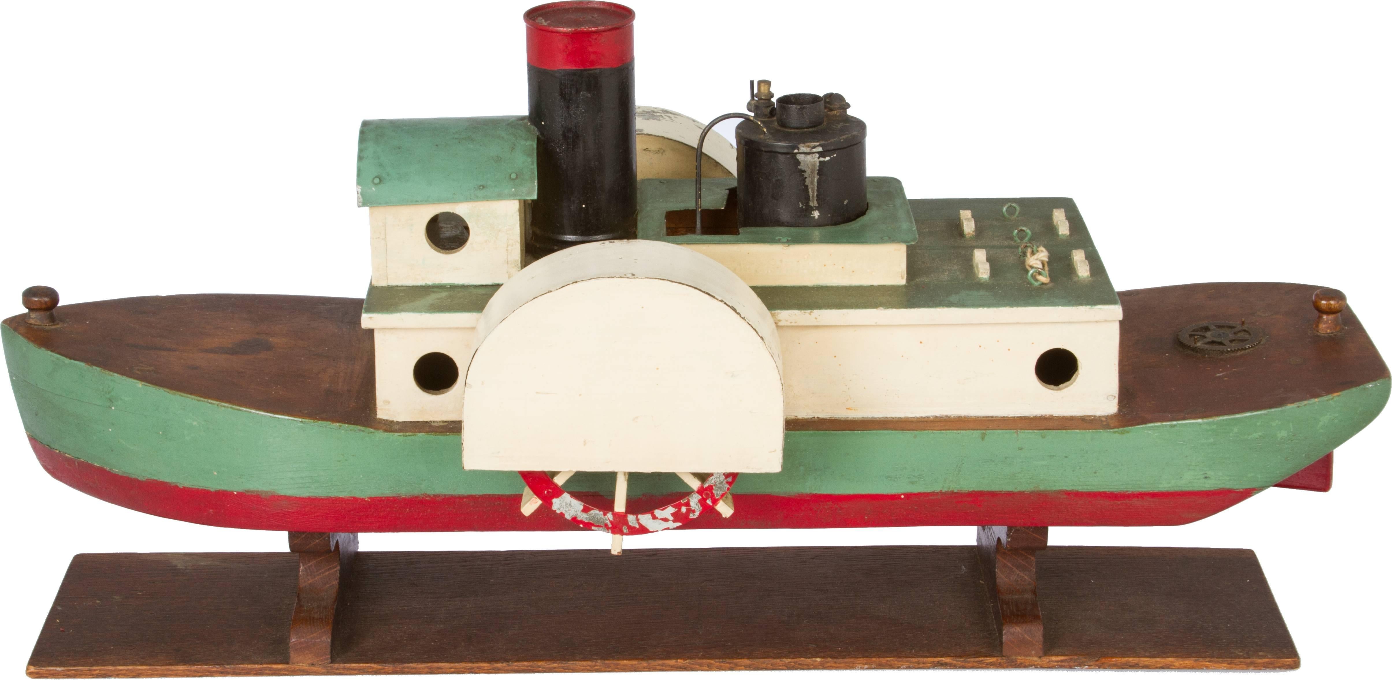 This fun Folk Art steam paddle boat is alcohol operated. It looks like the burner was never used.