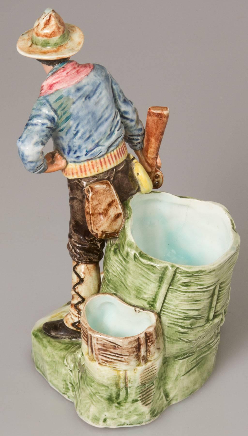 This is an unusual figural smoke stand having a match holder, striker and place to hold cigarettes or cigars.