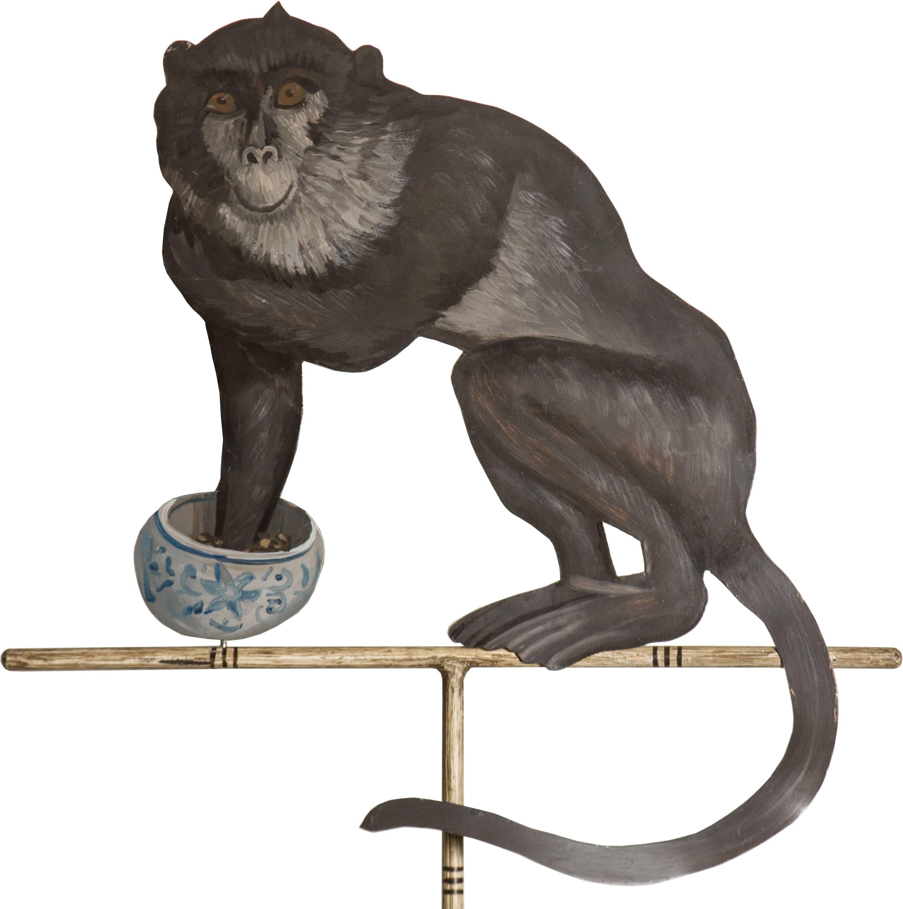 These are a whimsical pair of painted monkeys perched on stands.