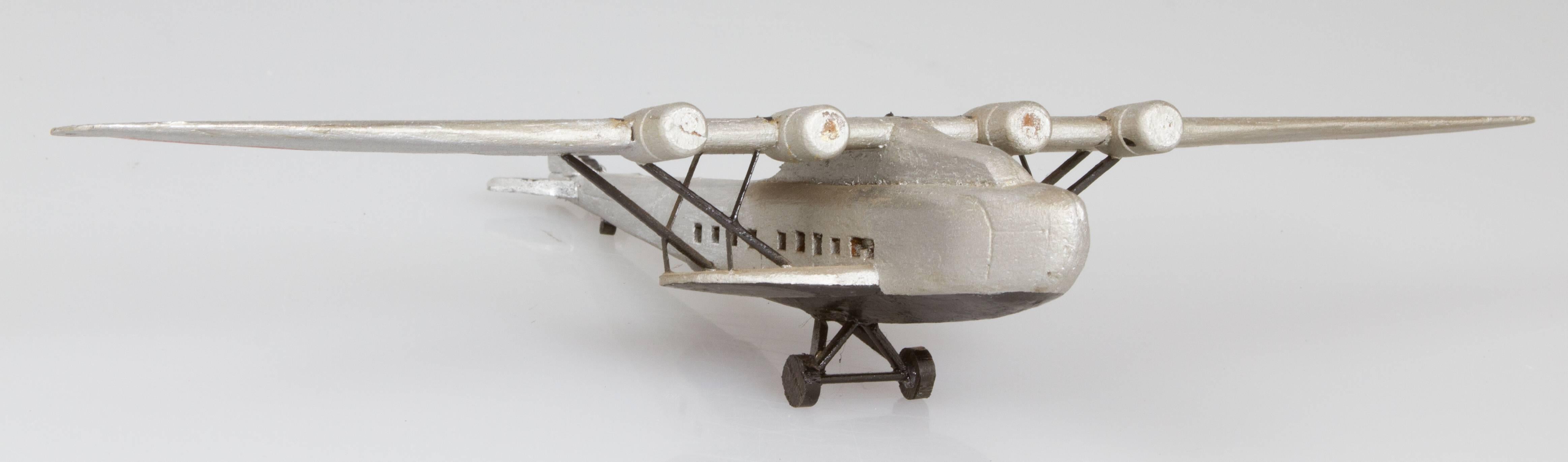 This is a charming hand-carved and constructed airplane. It is made out of balsa wood and hand-painted.