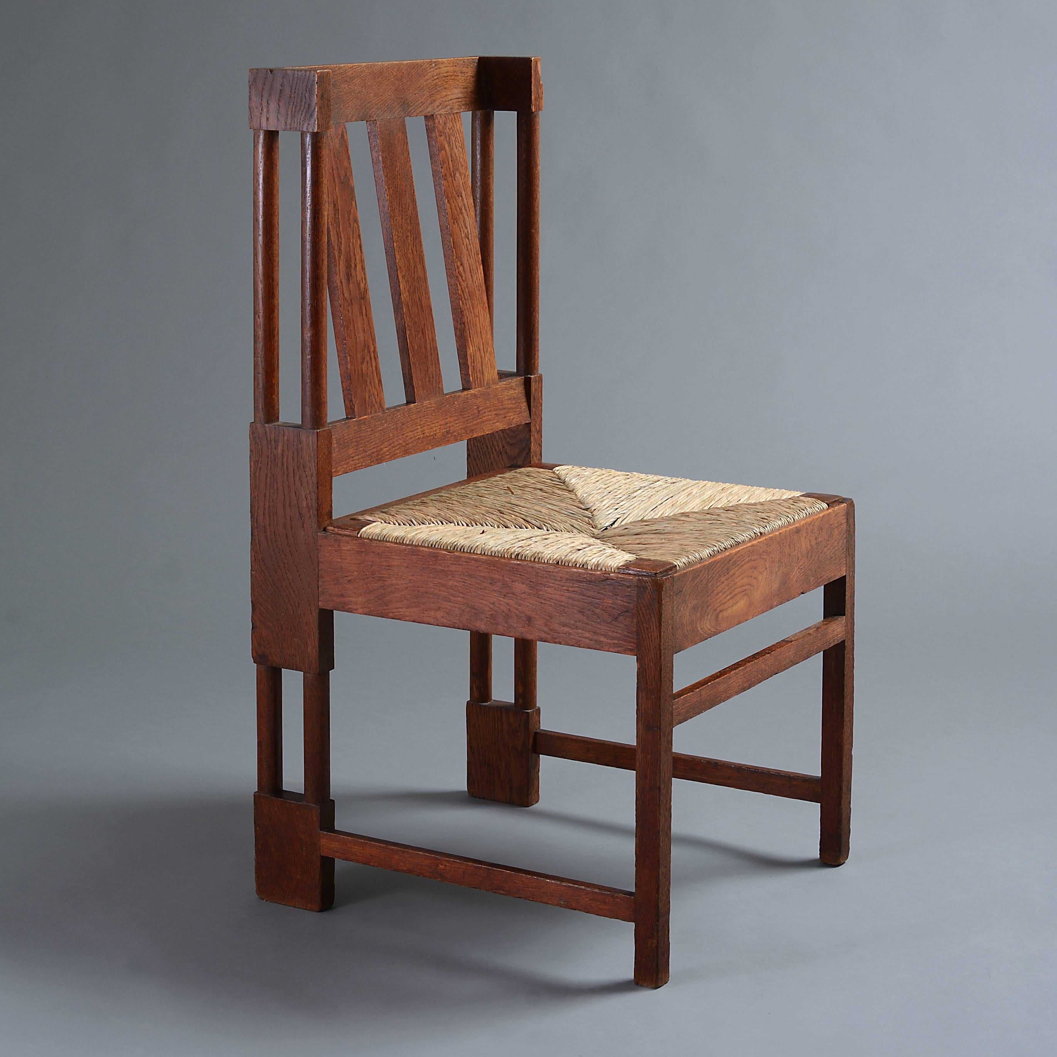An unusual pair of Arts & Crafts oak chairs, circa 1910.