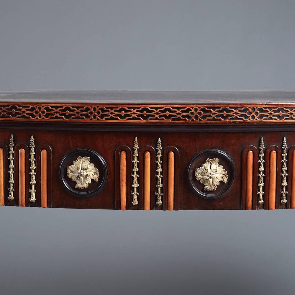 A George III mahogany side table in the manner of Sir William Chambers, circa 1770.

The eared serpentine top with a border applied with fine boxwood fretwork, the frieze applied with painted lead paterae alternating with boxwood flutes and painted