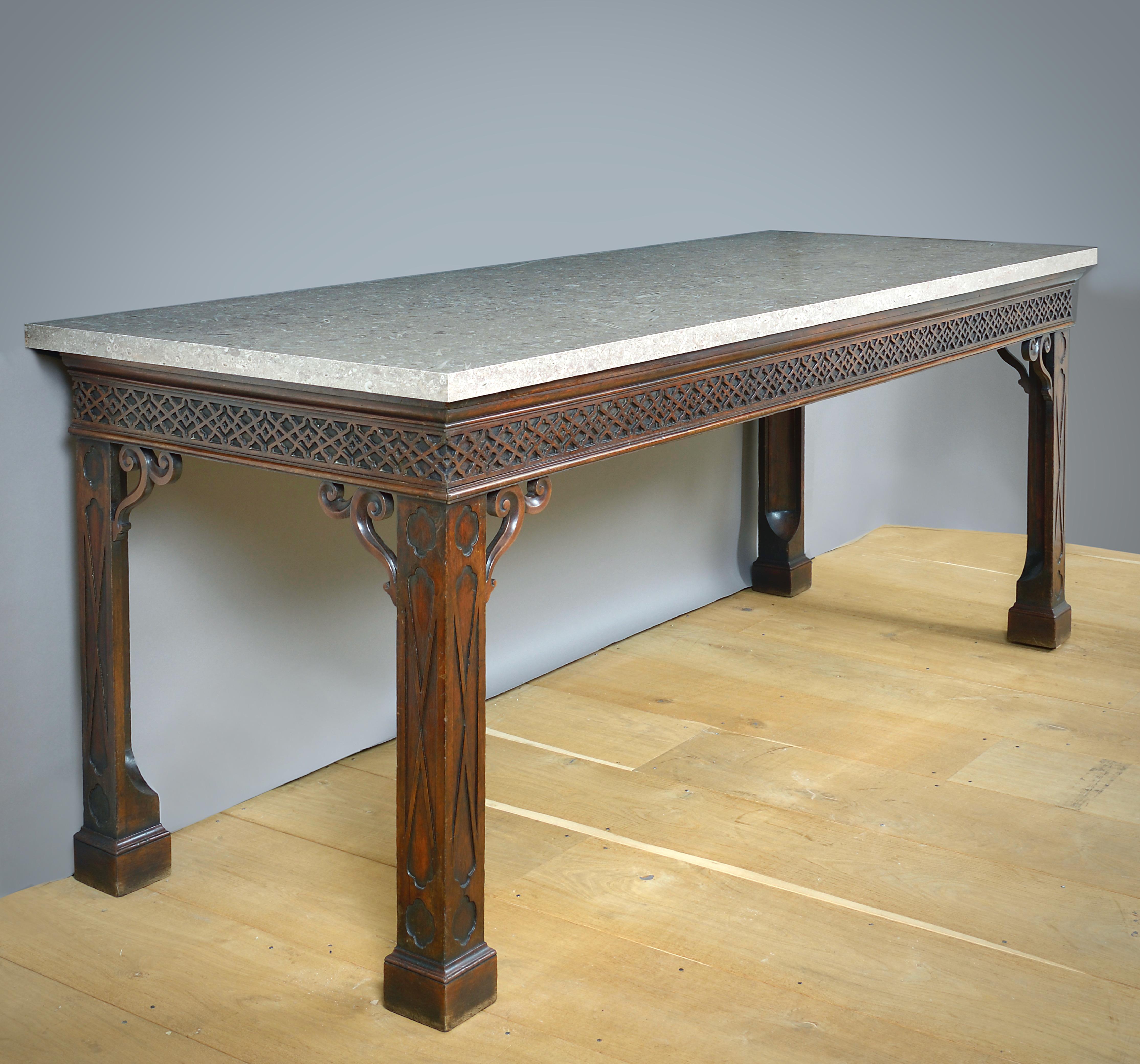 A MASSIVE GEORGE II MAHOGANY SIDE TABLE AFTER A DESIGN BY THOMAS CHIPPENDALE, POSSIBLY BY ALEXANDER PETER, CIRCA 1755-60.

With later Derbyshire fossil slab.