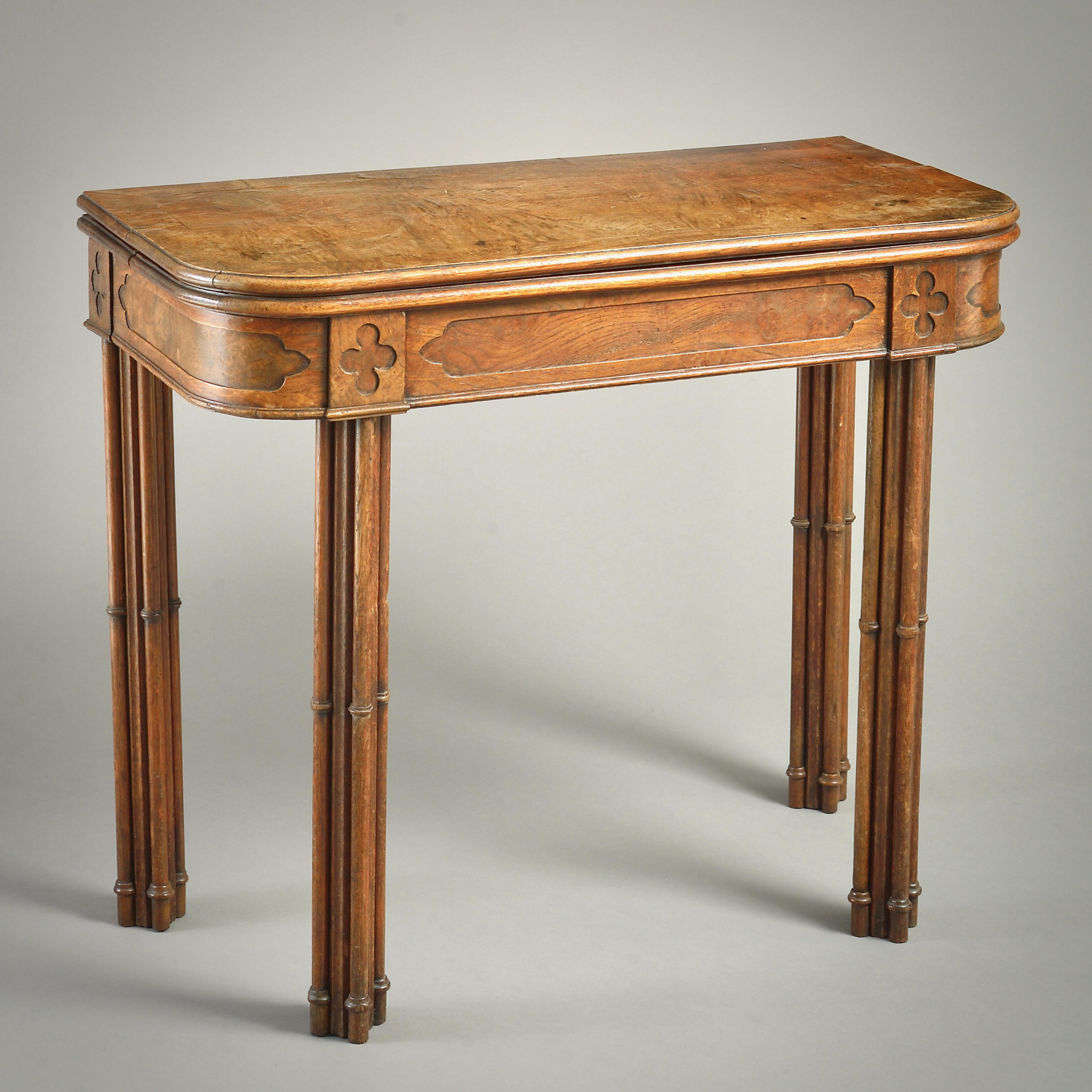 A REGENCY GOTHIC POLLARD OAK TEA TABLE, CIRCA 1820.

With banded fold-out top. The frieze with quatrefoil panels on cluster column legs.