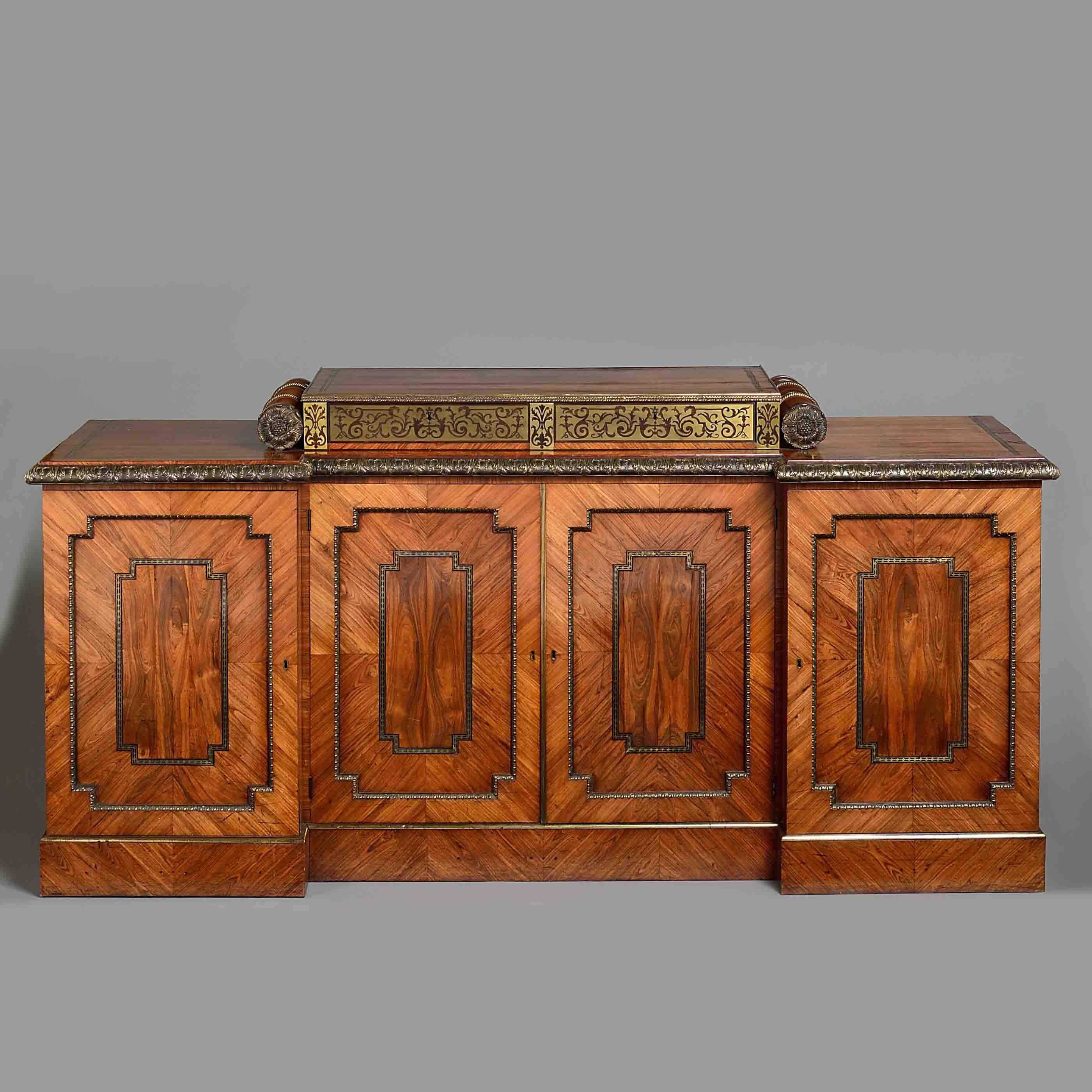 A magnificent Regency ormolu-mounted and brass-inlaid kingwood side cabinet in the manner of George Bullock, circa 1820.

The stepped top fitted with two brass marquetry doors flanked by massive turned balusters applied with paterae, the inverted