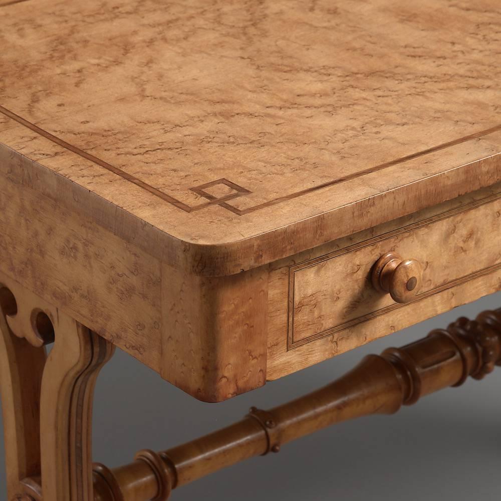 An early Victorian bird's-eye maple and tulip wood cross-banded writing table, circa 1840.