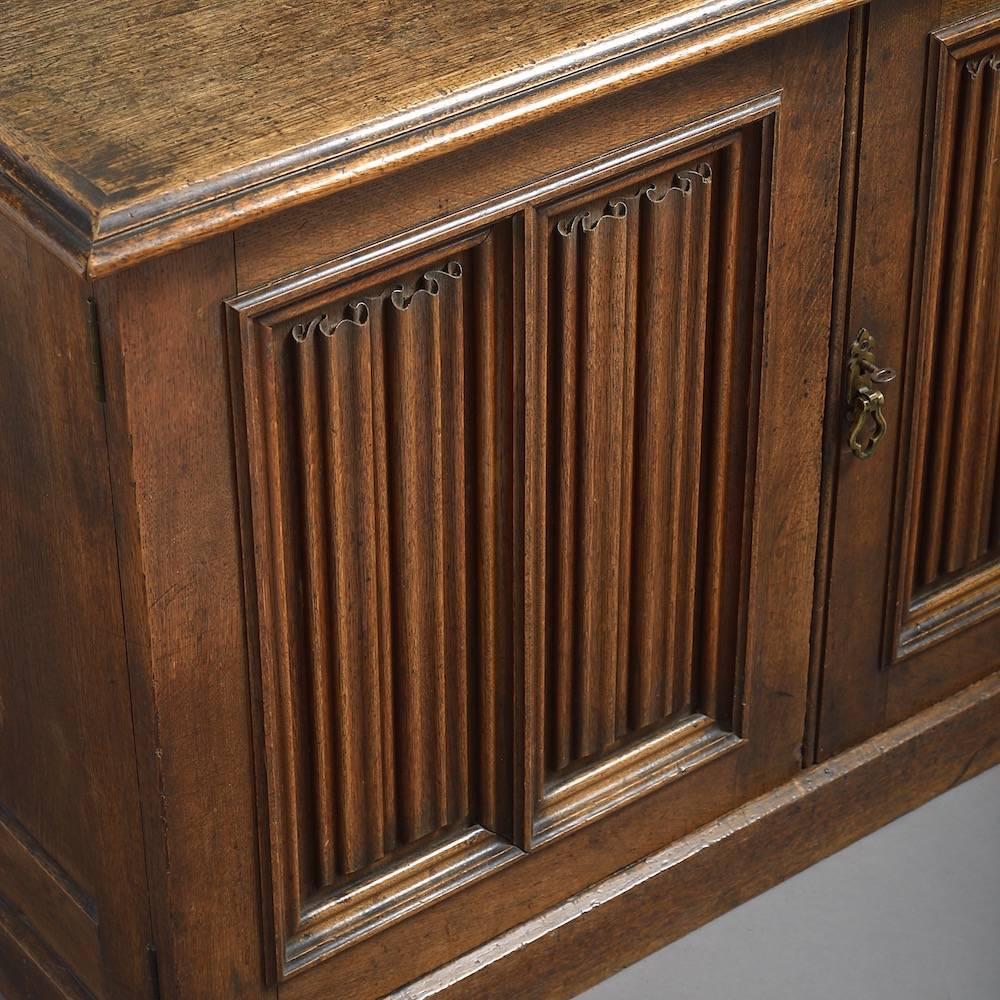 An early Victorian oak side cabinet with linenfold-panelled doors, circa 1850.