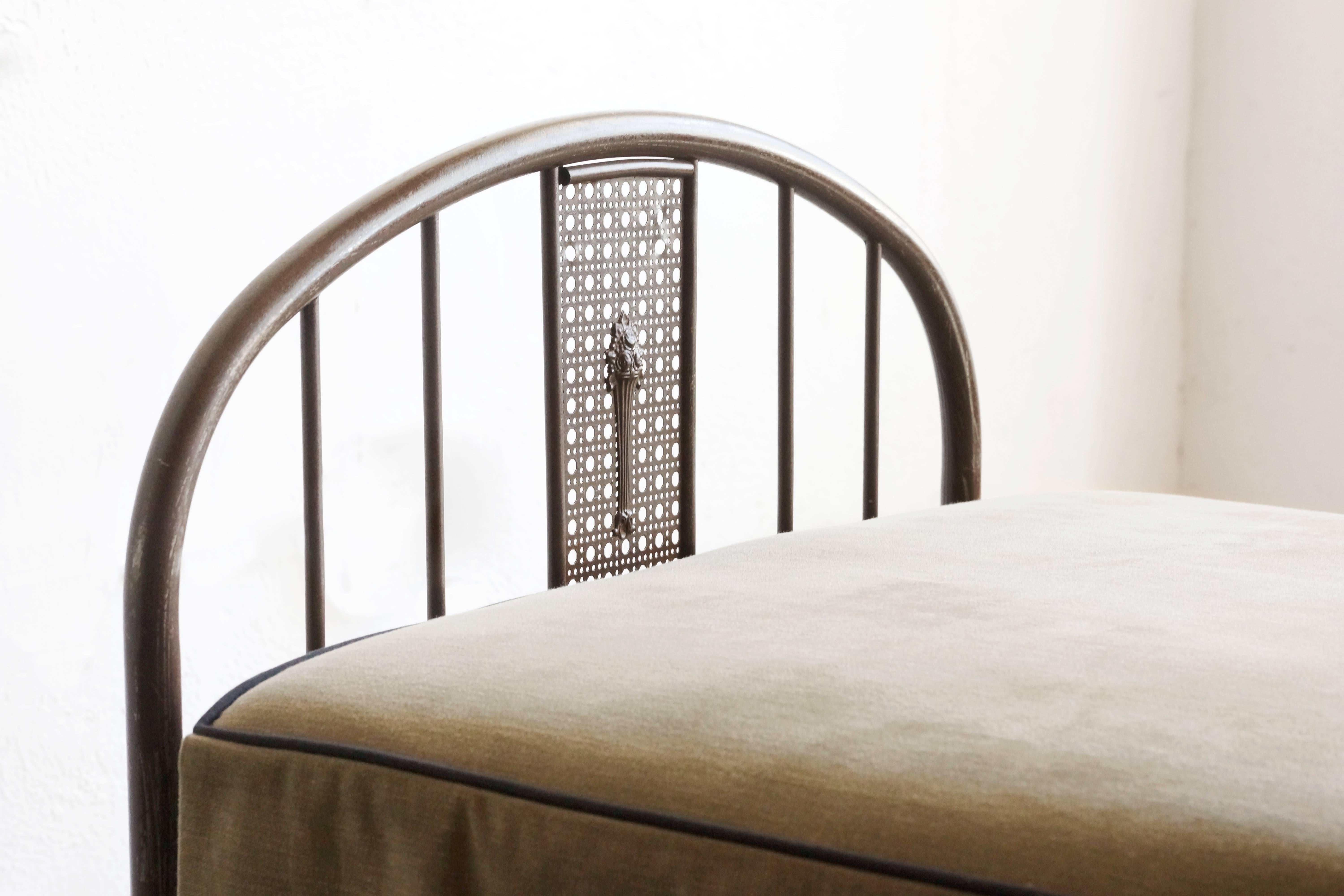 Beautiful antique metal cot circa 1930s, complete with vintage pad and bedcover. Cane-style detail pattern in the steel. Functional condition with vintage patina. Makes for a unique daybed/ guest bed. Head and foot-boards collapse/