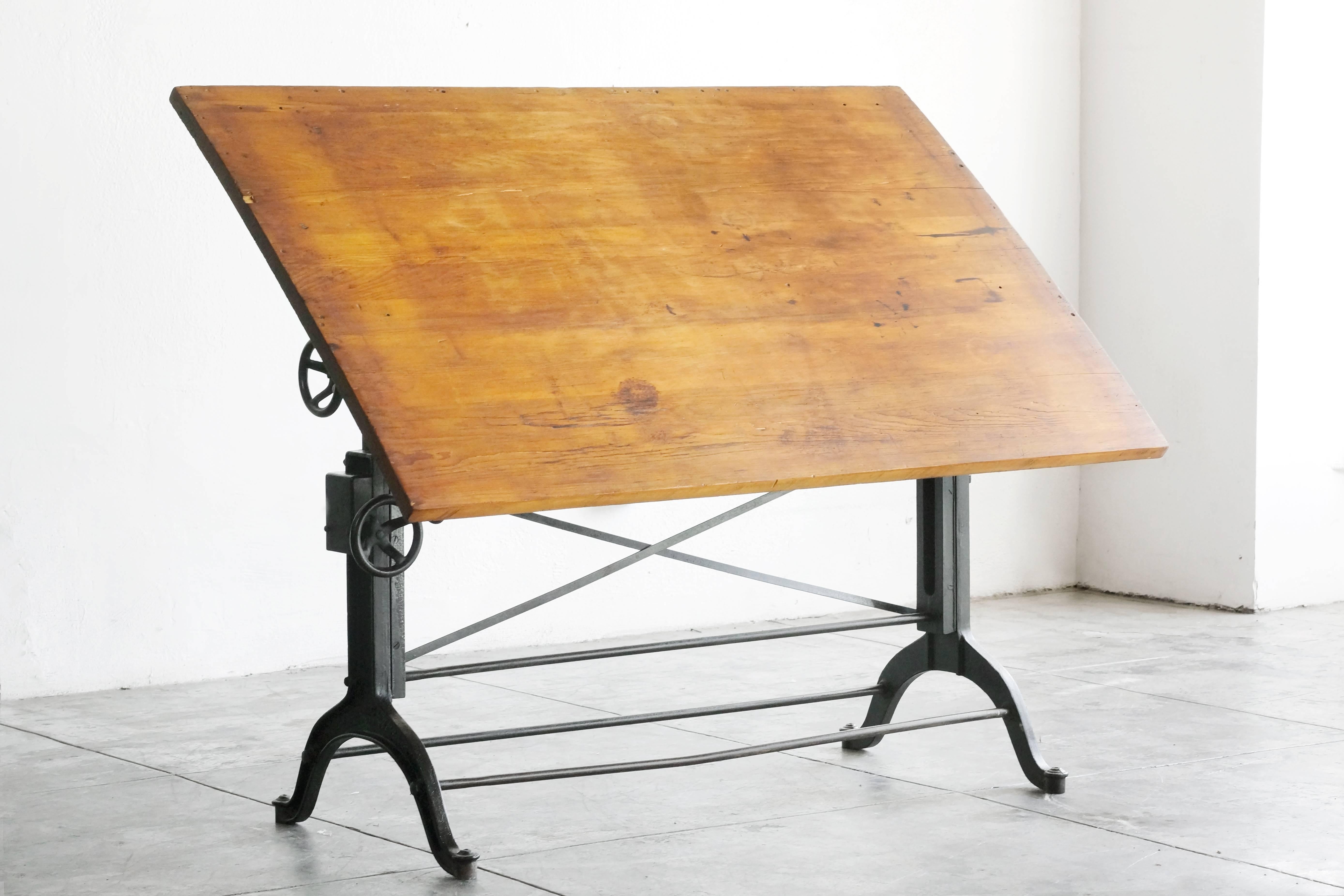 Early 1900s antique wood and cast iron drafting table by the Frederick Post Co. of Chicago, San Fransisco. This heavy-duty, fully adjustable table is in beautiful condition. Table-top shows a rich vintage patina.

Dimensions when top is parallel