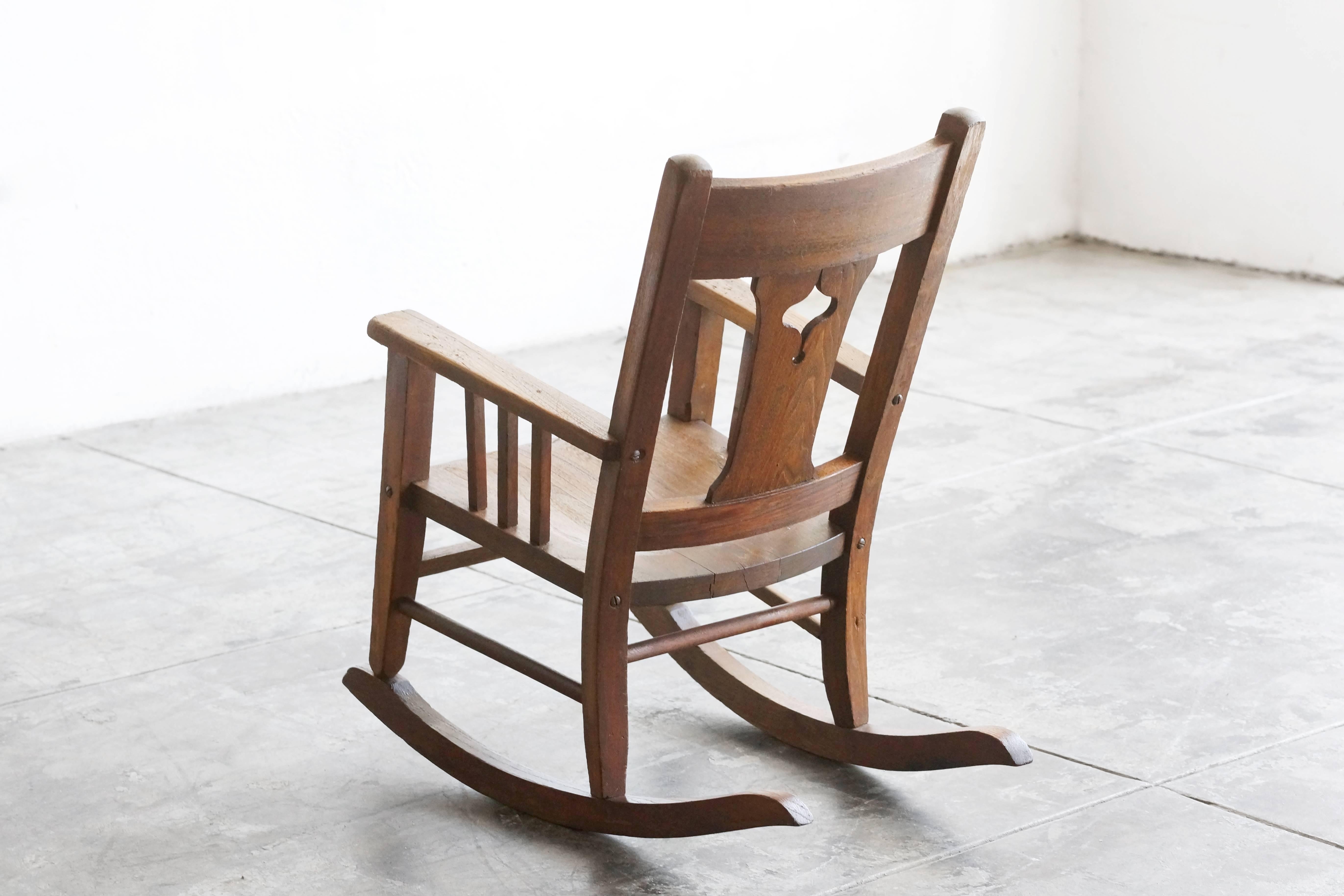 Craftsman style child's rocking chair, circa early 1900s. Solid wood, excellent craftsmanship, beautiful wood patina.

Measures: 24" D x 16" W x 26" H x 12" Seat height.