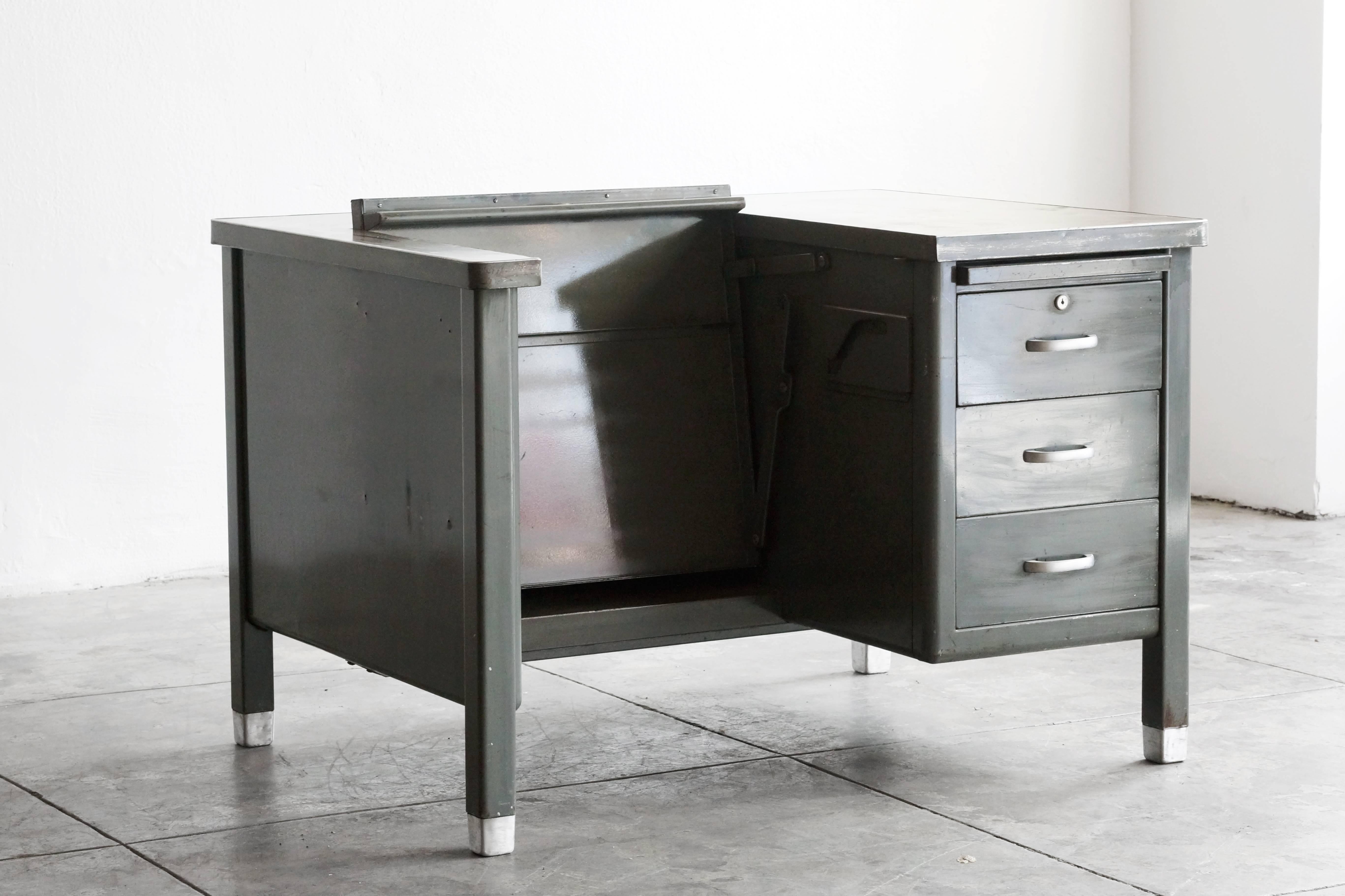 1920s single pedestal specialty tanker desk constructed to store a typewriter. This is a great example of an early tanker desk, complete with vintage industrial patina. Notice how the middle section tucks in (however, please note that this mechanism