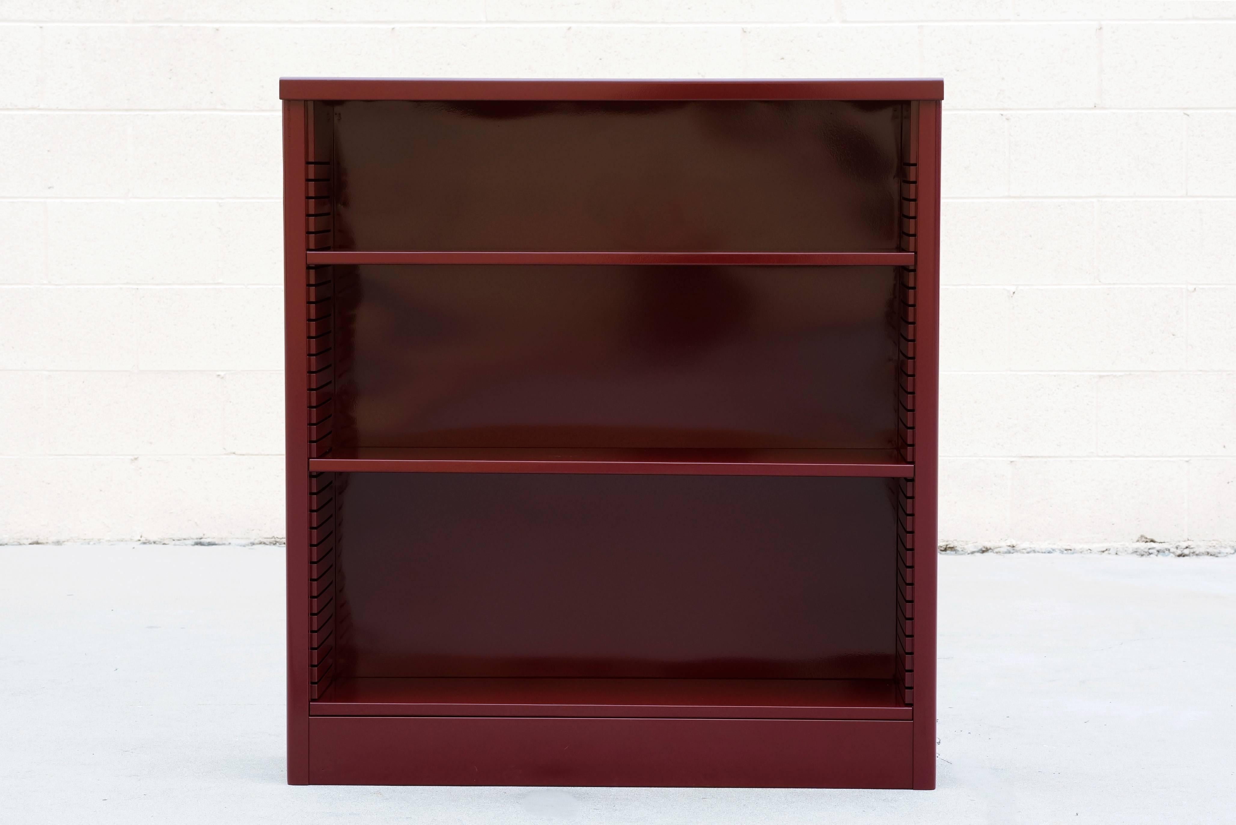 Neat 1960s tanker style steel bookcase freshly powder coated in high gloss wine red. Originally used in the UCLA math department, this adjustable three-shelf unit is an excellent storage option– its sleek and compact, yet holds many books. It's