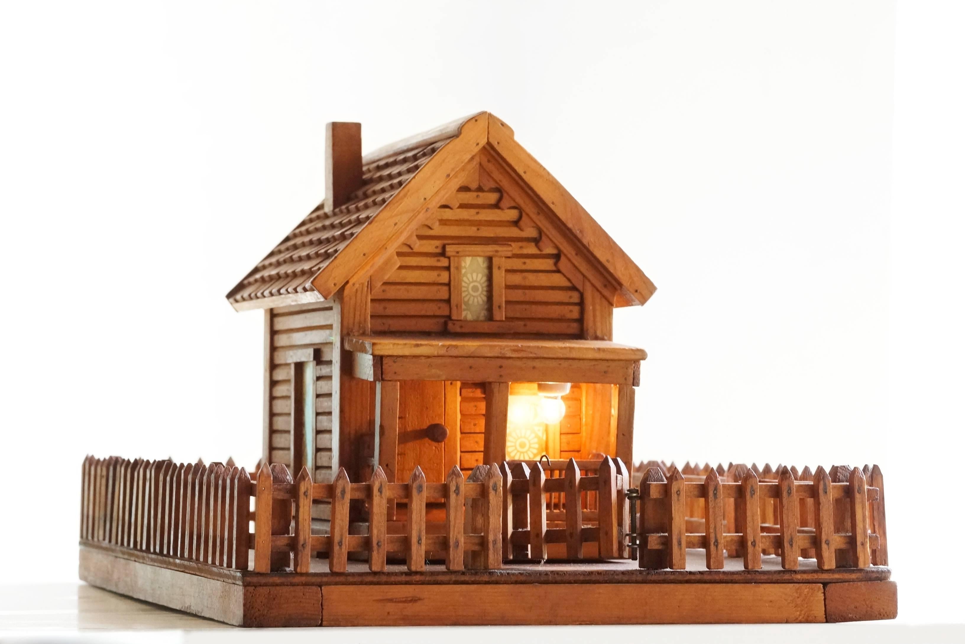 American Folk Art log cabin with working porch light. Absolute one-of-a-kind gem. Handmade of antique wood. Fully-functional and in excellent condition. Please note small blemish to right-hand window. 

Dimensions: 19